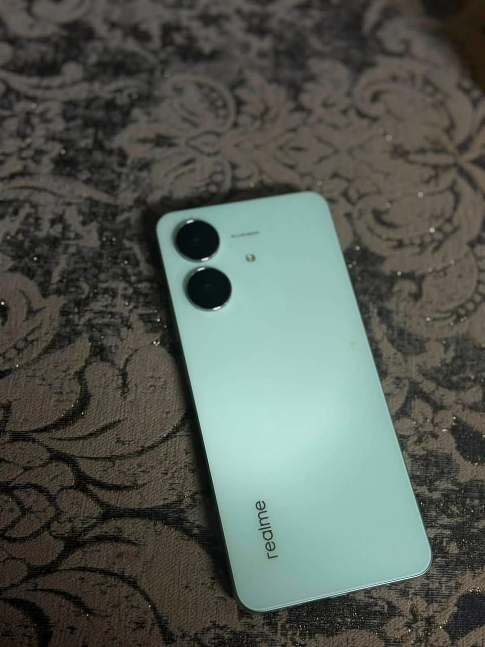 من الصورة، الهاتف هو realme Note 60x. هذه أبرز مواصفاته:
• الشاشة: 6.74 إنج HD+ بدقة 1600×720، مع معدل تحديث 90Hz لحركة أكثر سلاسة.  ￼

 • المعالج: UNISOC T612 ثماني النواة، مناسب للاستخدام اليومي مثل واتساب، يوتيوب، وتصفح الإنترنت.  ￼

 • الذاكرة: يتوفر بإصدارات مثل 3 أو 4 جيجابايت RAM مع 64 أو 128 جيجابايت تخزين، مع إمكانية إضافة بطاقة microSD حتى 2 تيرابايت (بحسب النسخة).  ￼

 • الكاميرا الخلفية: 8 ميجابكسل.

 • الكاميرا الأمامية: 5 ميجابكسل.  ￼

 • البطارية: 5000mAh تكفي عادة ليوم كامل، مع شحن 10 واط ومنفذ USB-C.  ￼

 • النظام: Android 14 مع واجهة realme UI.  ￼

 • الحماية: مقاومة للغبار ورذاذ الماء بمعيار IP54، وهيكل معزز ArmorShell Protection لتحمل الصدمات بشكل أفضل.  ￼

 • مزايا إضافية: منفذ سماعة 3.5 ملم، بصمة جانبية مدمجة بزر التشغيل، ويدعم شريحتي اتصال مع منفذ مستقل لذاكرة microSD.  

***********￼
السعرً:175الف
