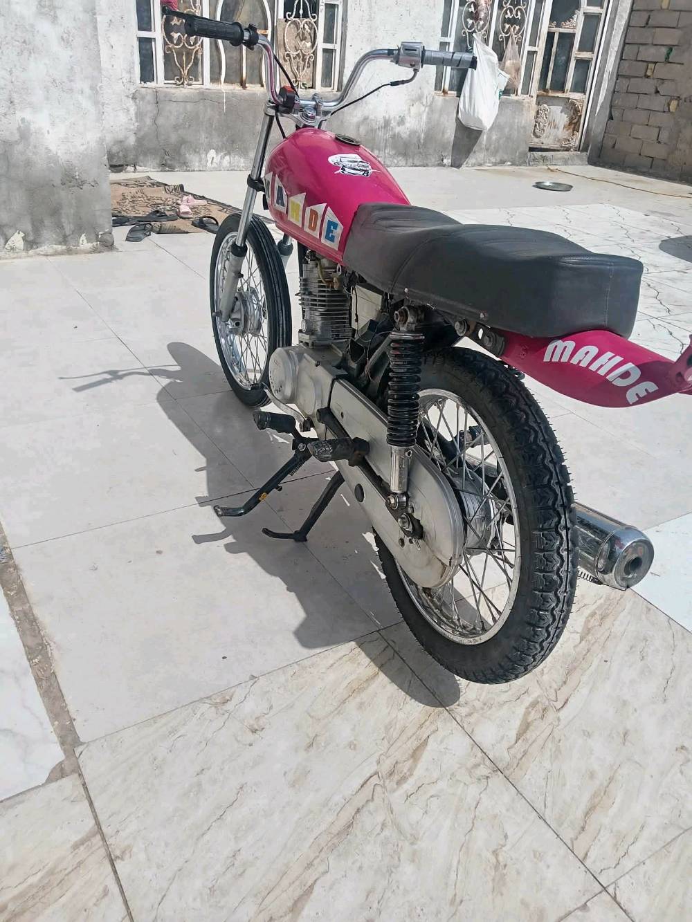 دراجة بخارية رائعة ذات لون وردي لامع ومزينة بكلمة MARDE على الجانبين. الدراجة بحالة جيدة وتعمل بسلاسة، مثالية للتنقل اليومي أو الاستعمال الشخصي. تحتوي على محرك قوي وقدرة تحمل جيدة، مما يجعلها مناسبة لمختلف أنواع الطرقات. شكلها المميز والتفاصيل الجميلة تضيف لمسة من الأناقة والتميز.