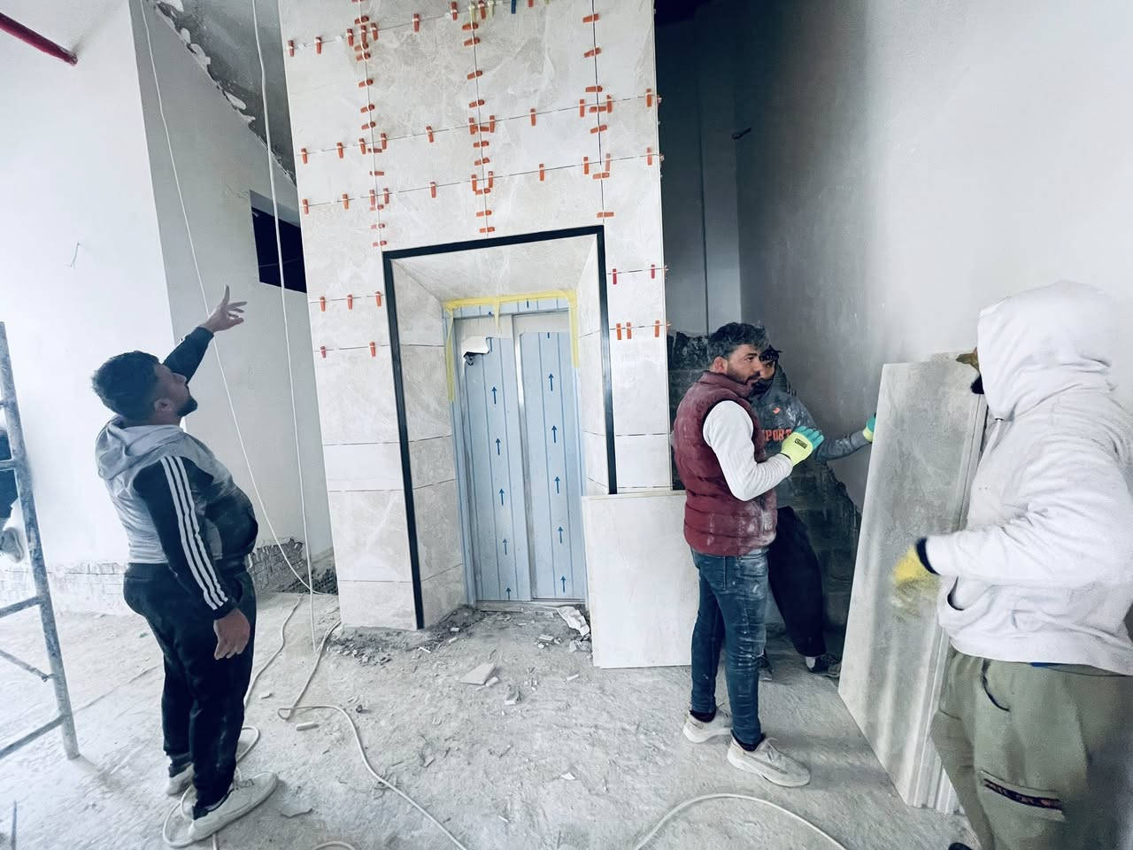 🔷  متابعة أعمال تغليف واجهة المصعد 🔷  

📍 الموقع: كركوك – طريق بغداد  
🏗️ اسم المشروع: بناية تجارية  

ضمن أعمال الإنهاءات، تمت متابعة تنفيذ تغليف واجهة المصعد باستخدام ألواح المرمر، وفق المواصفات الفنية المعتمدة، وبإشراف هندسي مباشر، حيث تضمنت الأعمال ما يلي:

▪️ تنفيذ الهيكل الحديدي الداعم (Substructure) وتثبيته باستخدام حديد 1.5 ملم (4*2) ومعالجته بمواد مقاومة للصدأ  
▪️ ضبط المحاور والاستقامة باستخدام أجهزة القياس لضمان دقة التنفيذ  
▪️ تجهيز وقص ألواح المرمر حسب الأبعاد التصميمية لفتحة المصعد  
▪️ تثبيت الألواح باستخدام مواد لاصقة عالية الجودة مع اعتماد نظام الربط الميكانيكي (Mechanical Fixing)  وزوايا تثبيت لضمان الأمان والاستقرار  
▪️ تنفيذ الفواصل الهندسية بين الألواح (Joints) بشكل منتظم لتحقيق المتانة والمظهر الجمالي  
▪️ تنفيذ الزوايا بطريقة الفريز (Mitre Cut 45°) لإظهار تشطيب معماري فاخر وإخفاء سماكة الألواح  
▪️ تنفيذ الإطارات المحيطة بفتحة المصعد بدقة عالية وبمستوى تشطيب متقدم  

📊 تم التأكيد خلال المتابعة على:
✔️ جودة المواد المستخدمة  
✔️ دقة التنفيذ والاستقامة  
✔️ كفاءة نظام التثبيت الميكانيكي  
✔️ جودة تنفيذ الزوايا والفواصل  
✔️ مطابقة الأعمال للمخططات والمواصفات  

📷 الصور المرفقة توضح مراحل التنفيذ من تركيب الهيكل الحديدي إلى أعمال تثبيت المرمر والتشطيبات النهائية.  

—    
🏢 مشروع بناية تجارية – كركوك  

#هندسة #اعمال_انهاءات #مرمر #مصاعد #كركوك #Construc


**إذا كنت صاحب هذا الإعلان وتريد حذفه لأي سبب، رجاءا أرسل رسالة إلى الدعم الفني**