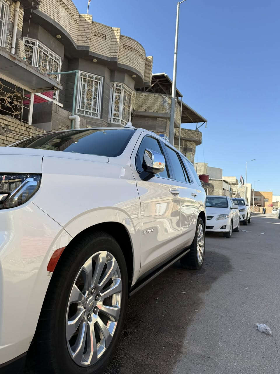 تاهو للبيع 2021السياره فول المواصفات جوه السياره كفاله عامه السياره مرقمه بغداد عنواني بصره الرقم الاماني الجديد 
وارد خليجي مغلفه ببف الون صدفي النضافه امبينه 
 السعر 490ورقه مكاني البصره الرقم ***********
سيارة شيفروليه تاهو بريمير (Premier) 2021 هي الفئة الأعلى (فل كامل) قبل فئة "هاي كاونتري"، وقد شهد هذا الموديل بداية الجيل الخامس بتغييرات جذرية في التصميم والتقنيات.
إليك أبرز مواصفات تاهو بريمير 2021:
1. الأداء والمحرك
• المحرك: V8 سعة 5.3 لتر (EcoTec3).
• القوة الحصانية: 355 حصان.
• عزم الدوران: 519 نيوتن متر.
• ناقل الحركة: أوتوماتيكي بـ 10 سرعات (بأزرار تبديل بدلاً من العصا التقليدية).
• نظام التعليق: تتميز فئة بريمير بنظام Magnetic Ride Control (التحكم المغناطيسي بالركوب) لتوفير سلاسة فائقة، مع توفر خيار نظام التعليق الهوائي التكيفي.
2. المواصفات الخارجية
• العجلات: جنوط ألومنيوم مقاس 22 بوصة.
• الإضاءة: مصابيح LED أمامية وخلفية كاملة.
• المرايا: قابلة للطي كهربائياً مع ميزة التدفئة والذاكرة ومؤشرات النقاط العمياء.
• الدرجات الجانبية: قابلة للتوضيب كهربائياً (في بعض النسخ) مع إنارة محيطية.
• صندوق الأمتعة: باب خلفي يفتح كهربائياً بتمرير القدم.
3. المقصورة والرفاهية
• المقاعد: جلد فاخر مع خاصية التدفئة والتبريد للمقاعد الأمامية، وتدفئة لمقاعد الصف الثاني.
• النظام الصوتي: نظام Bose Premium المكون من 10 مكبرات صوت.
• الشاشات:
• شاشة لمس مركزية مقاس 10.2 بوصة تدعم Apple CarPlay و Android Auto (لاسلكي).
• شاشة عدادات رقمية مقاس 8 بوصة.
• إمكانية وجود شاشات خلفية مقاس 12.6 بوصة لركاب الصف الثاني.
• الثلاجة: مدمجة في الكونسول الوسطي بقدرة تبريد عالية تصل إلى -5 درجات مئوية.
• السقف: فتحة سقف بانورامية واسعة.
4. أنظمة الأمان والتكنولوجيا
• الرؤية: كاميرات محيطية 360 درجة وشاشة عرض على الزجاج الأمامي (HUD) مقاس 15 بوصة.
• مساعدة السائق:
• تنبيه التصادم الأمامي مع فرملة طوارئ أوتوماتيكية.
• تنبيه مغادرة المسار مع المساعدة على البقاء في المسار.
• نظام تنبيه حركة المرور الخلفية والنقاط العمياء.
• حساسات ركن أمامية وخلفية.
