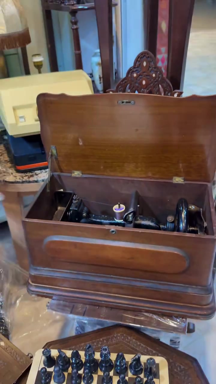 تُظهر الصورة ماكينة خياطة يدوية قديمة (Vintage Sewing Machine)، وهي موضوعة داخل حقيبة خشبية مخصصة لحمايتها وحملها. العمر التقريبي 140 عام 
تواصل واتساب ***********
