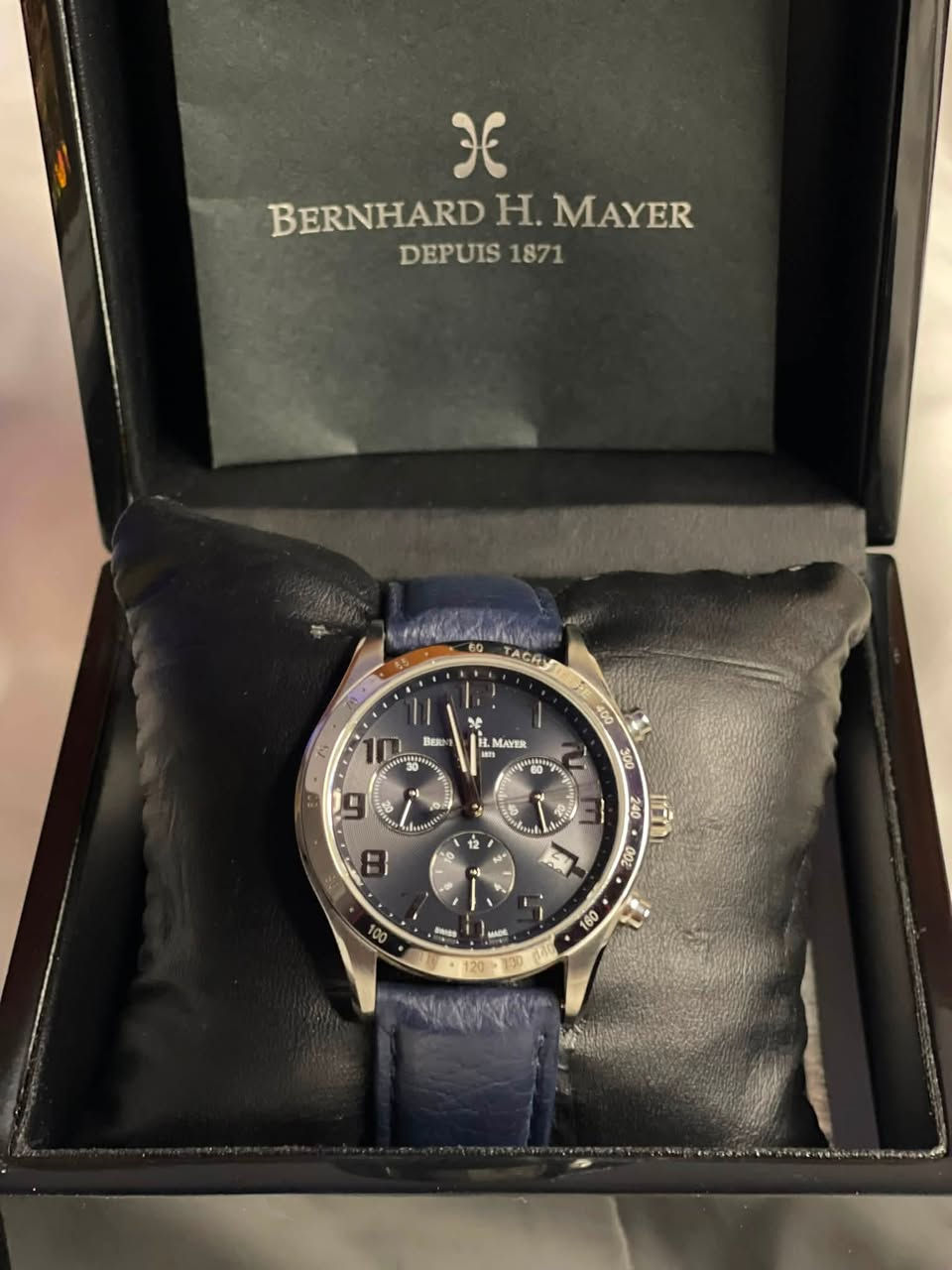 الماركة: برنهارد إتش ماير
التصنيف: ساعة يد كرونوغراف (Chronograph) كلاسيكية

الصنع" (Swiss Made).

الهيكل (Case): مصنوع بالكامل من الفولاذ المقاوم للصدأ المصقول عالي الجودة (All Stainless Steel).

الزجاج (Glass): زجاج من كريستال الياقوت (Sapphire Crystal) المضاد للخدش والصدمات، وهو ميزة أساسية في الساعات الفاخرة لحماية المينا.

الحزام (Strap): حزام مصنوع من الجلد الطبيعي الأزرق

السعر 400 دولار 
رقمي ***********
