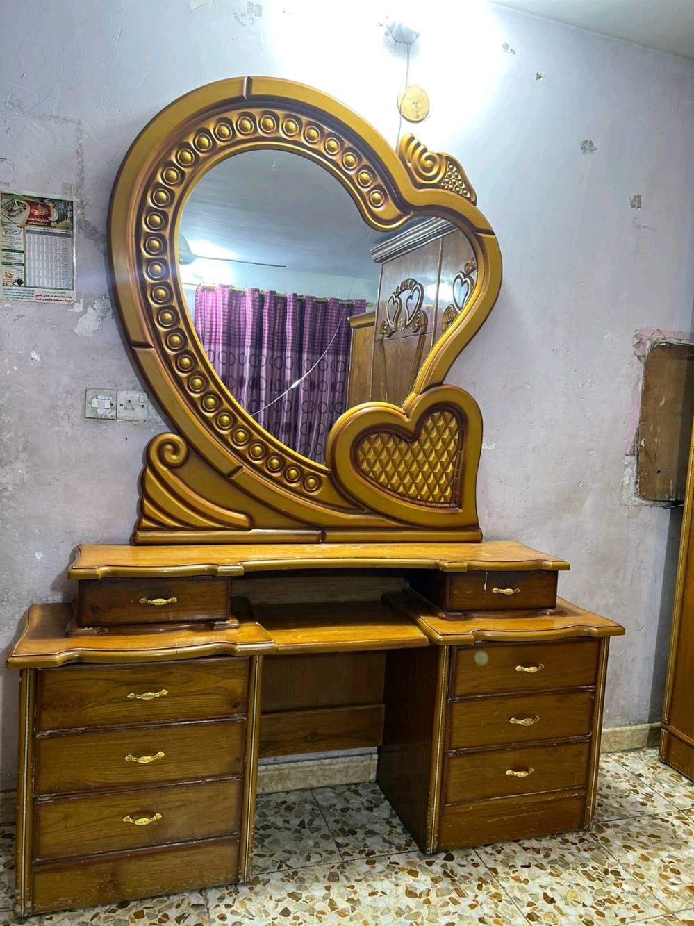 غرفة نوم خشبية أنيقة تتميز بالتصميم التقليدي والراقي مع نقوش قلبية جميلة على الخزانة والسرير. تحتوي على دولاب كبير مع مرايا أنيقة، بالإضافة إلى تسريحة مع مرآة واسعة تكمل جمال الغرفة. تُعد الغرفة مثالية لمن يحب الطراز الكلاسيكي وتناسب أي ديكور منزلي. حالة الخشب جيدة وتصميم الأثاث يضفي طابعاً مميزاً لأي غرفة نوم.