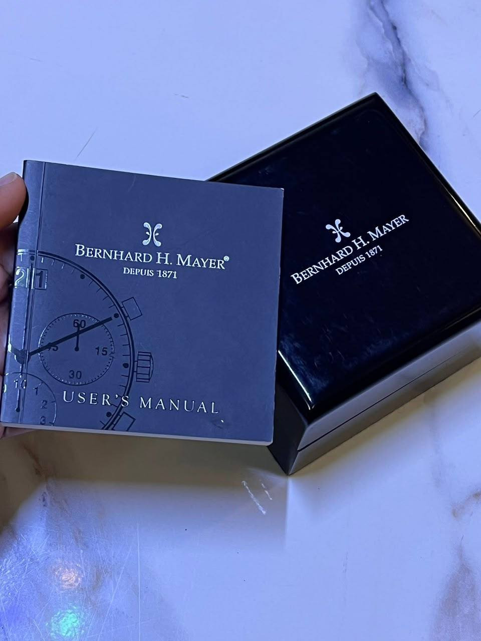 ​⌚️ ساعة سويسرية فاخرة Bernhard H. Mayer للبيع (إصدار محدود)
للبيع ساعة رجالية راقية جداً وأصلية من الماركة السويسرية العريقة Bernhard H. Mayer (Depuis 1871). التحفة الفنية تأتي كاملة الملحقات وبحالة ممتازة جداً.

​⚜️ مواصفات الساعة الفنية:

​بلد الصنع: سويسرا (Swiss Made) بكل أجزائها.

​الحركة: كوارتز سويسري دقيق وعالي الجودة (Swiss Quartz - Ronda 4120.B).

​الزجاج: سافير كريستال مقاوم للخدش تماماً مع طبقة مضادة للانعكاس (Scratchproof Sapphire Crystal).

​الهيكل والسوار: ستانلس ستيل خالص (فولاذ مقاوم للصدأ) مصقول بحرفية عالية.

​القطر: 40 ملم (قياس مثالي ومناسب لكافة المعاصم).

​مقاومة الماء: حتى 50 متراً (5 ATM).

​الوظائف المتطورة: تحتوي على نافذة تاريخ كبيرة (Big Date) وخاصية المنبه الفريدة (RÉVEIL) مع عقرب ثواني فرعي.

​🌟 مميزات إضافية للمقتنين:

​الإصدار: إصدار محدود ونادر (Limited Edition) تم إنتاج 9999 قطعة منه فقط حول العالم.

​الرقم التسلسلي المميز: 0774 / 9999 (محفور على خلفية الساعة ومثبت بشهادة الأصالة).

​الملحقات الكاملة: تأتي مع العلبة الفاخرة الأصلية، كتيب المستخدم (User's Manual)، وشهادة الأصالة والضمان الدولي (Statement of Authenticity).

​📞 للتواصل والاستفسار (اتصال مباشر أو واتساب):

​***********

