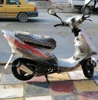 دراجة نارية سكوتر بحالة ممتازة، مغلفة بالكامل لحمايتها من الخدوش. مثال...