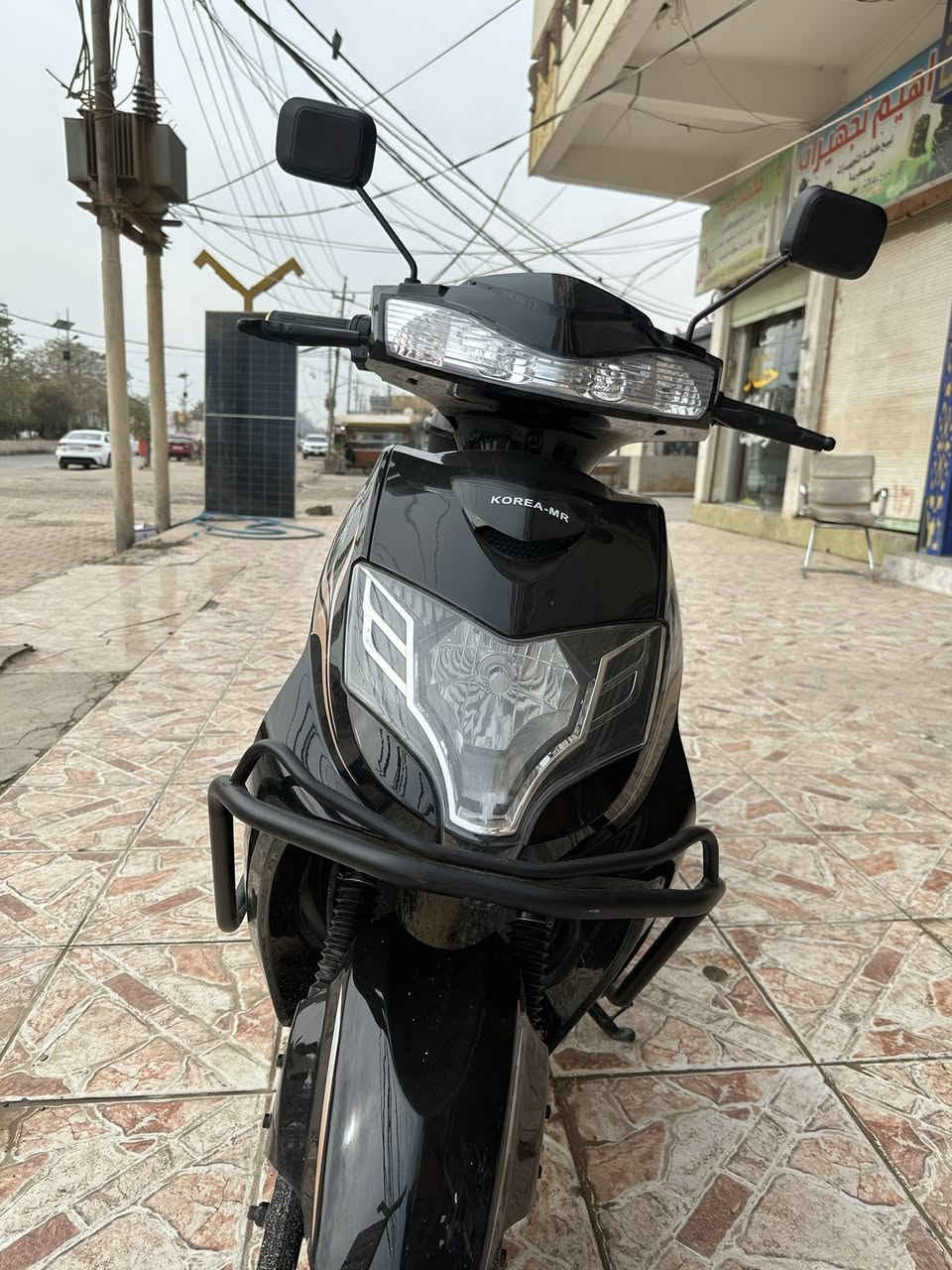 🔹 النوع
سكوتر كهربائي ( KOREA-MR ) 
مناسب للمشاوير القريبة والتنقل اليومي
🔹 التصميم
لون أسود لامع مع خطوط جانبية أنيقة
تصميم انسيابي وشبابي
مرايات جانبية عريضة للرؤية الواضحة
مصباح أمامي كبير LED يعطي إنارة قوية بالليل
مسند قدم واسع ومريح
🔹 المواصفات المتوقعة (تقريبية حسب هذا النوع)
⚡ المحرك: كهربائي (عادة 800 – 1500 واط)
🔋 البطارية: غالبًا رصاص جل
⏱️ الشحن: 6 – 8 ساعات تقريبًا
🚀 السرعة القصوى: 40 – 50 كم/س
📏 المدى: 40 – 60 كم بالشحنة الواحدة
🪑 الحمولة: شخص أو شخصين (حدود 150–180 كغم)
🔹 الأمان والراحة
فرامل أمامية وخلفية
إشارة يمين ويسار.                              ملاحضه موديل 2025
ضوء خلفي + ضوء توقف.                   صارلي شهر من مآخذه 
قاعدة جانبية + وسطية
مقعد مريح وارتفاعه مناسب
🔹 المميزات
ما يحتاج بنزين ⛽
هادئ جدًا
اقتصادي (شحنه أرخص هواي من البنزين)
سهل الاستخدام  تواصل ***********
