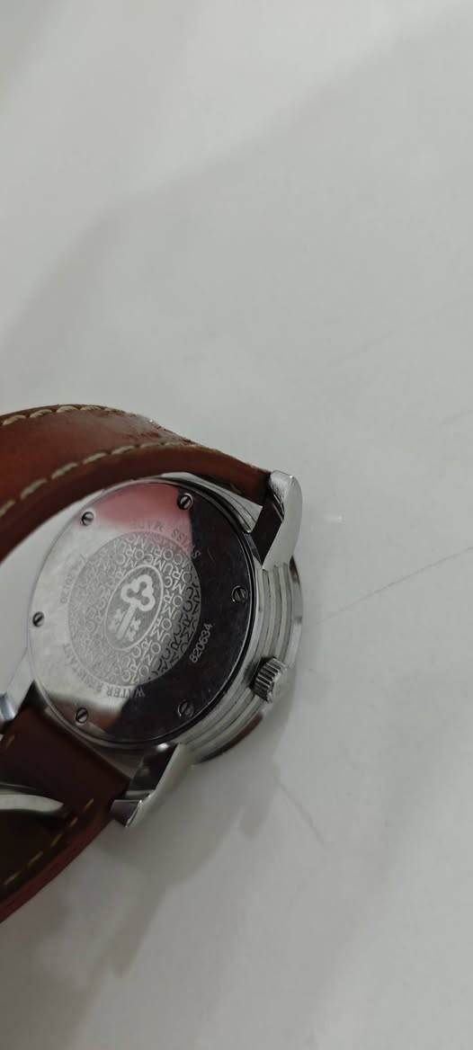 في الصورة هي ساعة Corum Classical Jump Hour (ساعة كوروم ذات الساعة القافزة)، وهي إصدار محدود (Limited Edition) يتميز بتصميم فريد لعرض الوقت.المميزات والمواصفات الفنيةنظام الساعة القافزة (Jump Hour): بدلاً من عقرب الساعات التقليدي، تظهر الساعة الحالية من خلال نافذة صغيرة (فتحة) عند موضع الساعة 12.عرض الدقائق والثواني: تحتوي على عقرب مركزي كبير للإشارة إلى الدقائق على مقياس "انفجاري" للأرقام العربية، بالإضافة إلى ميناء فرعي صغير للثواني عند موضع الساعة 6.الإصدار: هذا الموديل إصدار محدود للغاية، حيث تم إنتاج 300 قطعة فقط منه حول العالم (القطعة في الصورة تحمل رقم 189 من 300).الحجم والمادة: تأتي بهيكل من الفولاذ المقاوم للصدأ (Stainless Steel) بقطر يبلغ غالباً 42 ملم.المحركة: تعمل بحركة ميكانيكية (يدوية التعبئة في بعض الموديلات وأوتوماتيكية في أخرى).


**إذا كنت صاحب هذا الإعلان وتريد حذفه لأي سبب، رجاءا أرسل رسالة إلى الدعم الفني**