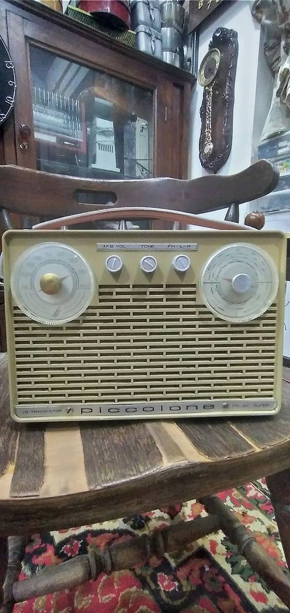 جهاز  راديو ترانزستور كلاسيكي نادر من طراز Piccolone،  من إنتاج شركة SABA الألمانية العريقة (غالباً موديل من أوائل الستينيات). يتميز هذا الراديو بتصميمه الذي يجمع بين البساطة الهندسية والفخامة التقنية لتلك الحقبة.
​إليك التفصيل الفني والجمالي لهذه القطعة:
​ المواصفات التقنية (من الواجهة)
​نظام الترانزستور: مكتوب عليه "10 Transistor"، وهو ما كان يعتبر طفرة تقنية في وقته، حيث تضمن هذه الترانزستورات جودة التقاط عالية وصوت نقي مقارنة بالأجهزة الأقدم.
​الموجات والترددات:
​الميناء الأيسر: مخصص لموجة الـ FM (ترددات من 88 إلى 104 ميجاهرتز).
​الميناء الأيمن: مخصص للموجات الطويلة والمتوسطة (LW/MW).
​أدوات التحكم: يحتوي على ثلاثة مفاتيح في المنتصف:
​AFB VOL: للتحكم في التشغيل ومستوى الصوت.
​TONE: للتحكم في حدة الصوت (Bass/Treble).
​FM-L-M: مفتاح التنقل بين الموجات الثلاث.
​2. التصميم الخارجي
​الهيكل: مصنوع من البلاستيك المقوى (Bakelite أو بلاستيك عالي الجودة) بلون "كريمي" أو بيج فاتح، مع مقبض علوي جلدي مريح للحمل.
​الشبكة الأمامية: صُممت بشكل خطوط عرضية متقطعة تسمح بخروج الصوت بوضوح وتمنحه مظهراً كلاسيكياً (Retro).
​الميناء (Dials): الأقراص الدائرية الكبيرة شفافة مع مؤشرات حمراء دقيقة، وهي علامة مميزة لتصاميم الستينيات الأوروبية.
​ القيمة التاريخية
​علامة SABA الألمانية كانت منافساً قوياً لشركات مثل "تيلفونكن" و"جرونديج"، وتعتبر أجهزتها اليوم من القطع المرغوبة جداً لدى هواة جمع الأنتيك لجودة صناعتها وطول عمرها الافتراضي.
​يُطلق عليه اسم "Super" (مكتوب في الزاوية اليمنى السفلى)، وهي إشارة إلى تقنية "Superheterodyne" في استقبال الإشارات اللاسلكية.
​نصيحة للعناية بالقطعة:
​بما أن الهيكل من البلاستيك القديم، يُفضل تنظيفه بقطعة قماش ناعمة مبللة قليلاً بالماء وتجنب المنظفات الكيميائية القوية التي قد تتسبب في بهتان اللون أو تشقق البلاستيك.


**إذا كنت صاحب هذا الإعلان وتريد حذفه لأي سبب، رجاءا أرسل رسالة إلى الدعم الفني**