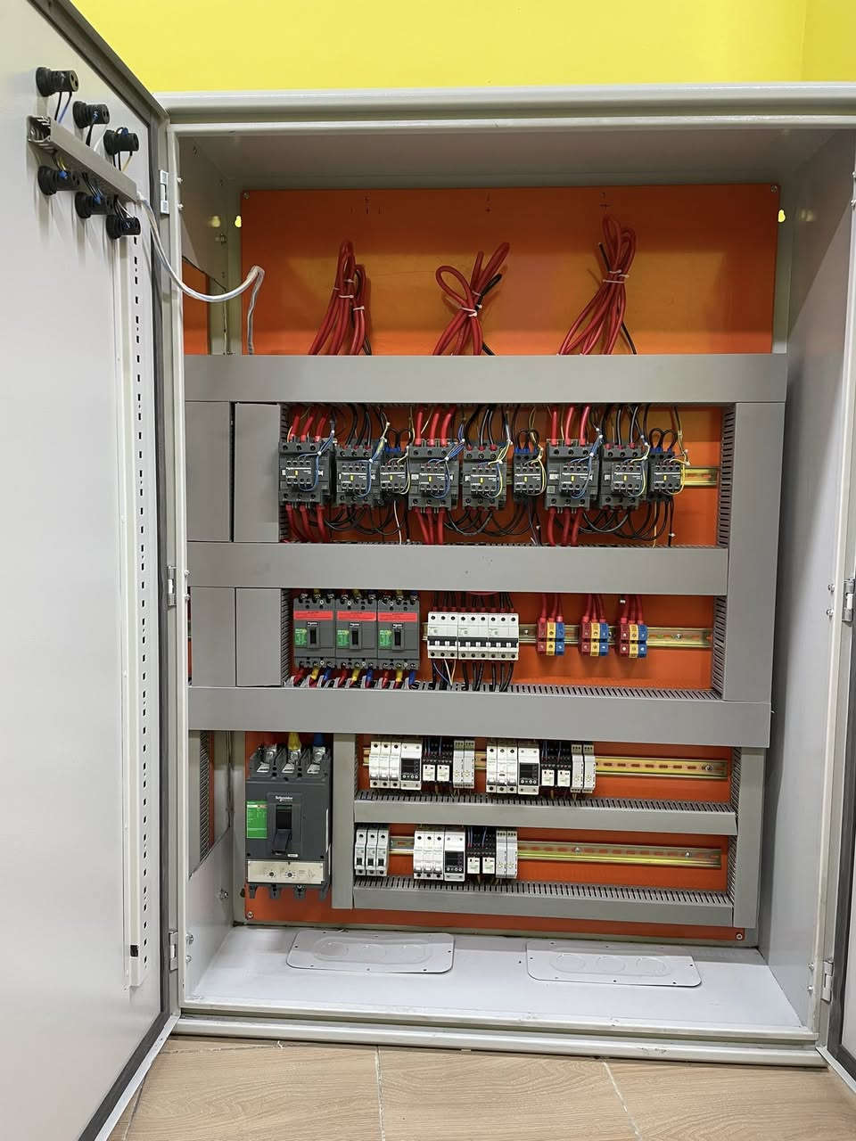 عندما تتحول موثوقية الطاقة إلى معيار هندسي مُحكم و ليس مجرد قرار تجاري عابر..

في المشاريع السكنية الحديثة ، إدارة الطاقة ليست مجرد تغذية كهربائية ، بل منظومة متكاملة من الاعتمادية ، السلامة ، و دقة القياس.
بتوفيق الله ، قمنا بتصميم و تصنيع لوحة تحويل تلقائي (Automatic Transfer Switch – ATS) متقدمة ، تعتمد على حلول Schneider Electric ، لتخدم عمارة سكنية مكونة من 7 وحدات مستقلة ، مع نظام تحويل آلي منفصل (Independent Automatic Transfer System) لكل شقة ، وفق أفضل الممارسات الهندسية العالمية.

⚡ البنية الهندسية للنظام | المواصفات الفنية : 
- تم تصميم و تنفيذ لوحة تحويل تلقائي (Automatic Transfer Switch – ATS) بهيكلية هندسية مدروسة و بأبعاد 200 × 140 سم ، قادرة على استيعاب الأحمال العالية مع ضمان توزيع طاقة متوازن (Balanced Load Distribution) و استقرار تشغيلي طويل الأمد.
- تعتمد المنظومة على مصدرَي تغذية رئيسيين : 
❶ مصدر الشبكة الوطنية (Utility Power Source) 
❷ مصدر المولد الاحتياطي (Backup Generator Source)
وذلك عبر قاطعَي دخول رئيسيين بسعة (400A) لضمان موثوقية التحويل و استمرارية التغذية.
- منظومة تحويل مستقلة : تم اعتماد نظام تحويل آلي مستقل (Independent Automatic Transfer System) لكل شقة من خلال لوحة ATS منفصلة تضمن الفصل الكامل بين الوحدات السكنية (إدارة الطاقة لكل شقة بشكل مستقل) ، و تتكون كل لوحة ATS من خمسة مكونات رئيسية :
❶ قاطع دخول رئيسي (MCCB 100A)
❷ قاطع حماية ثلاثي (MCB 63A)
❸ كونتكتر رئيسي (Main Contactor 125A)
❹ كونتكتر تحويل (Transfer Contactor 80A)
❺ كونتكتر خط السحب (Load Shedding Contactor 25A)
- فلسفة الحماية و التحكم : تم تطوير منظومة الحماية و التحكم وفق فلسفة هندسية مدروسة ، تهدف إلى ضمان استقرار النظام الكهربائي و حماية الأحمال و منع أي تداخل غير مرغوب بين مصادر التغذية ، و ابرز مكونات الرئيسية هي :
❶ جهاز حماية الجهد الكهربائي 
(Over / Under Voltage Protection Relay)
❷ مؤقت زمني (2 × Time Delay Relays) للتحكم بتسلسل التحويل و تقليل الصدمات الكهربائية و منع التداخل بين مصادر التغذية.

⚡ القيمة التشغيلية | الفوائد المحققة :
• حماية شاملة للأحمال من تيار الحمل الزائد (Overload Current) و تيار القصر الكهربائي (Short Circuit Current) عبر منظومة القواطع الرئيسية و الفرعية ، بما يضمن الفصل الفوري للأعطال و منع ارتفاع درجات الحرارة أو تلف المكونات.
• حماية الجهد الكهربائي من الارتفاع و الانخفاض (Over / Under Voltage Protection) فيما يخص الشبكة الوطنية ، لمنع تلف الأجهزة الحساسة الناتج عن عدم استقرار الفولتية.
• منع التداخل بين مصادر التغذية (Source Interlocking Protection) مع حماية الأحمال أثناء التحويل عبر تسلسل زمني مدروس (Time Delay Transfer Logic) بأستخدام تايمرات زمنية (Time Delay Relays) ، بما يضمن عدم تزامن الشبكة الوطنية مع المولد و تقليل الصدمات الكهربائية أثناء الانتقال بين المصادر.
• يوفر النظام فصل كامل للأحمال بين الوحدات السكنية عبر نظام تحويل مستقل (Independent ATS System) ، مما يمنع انتقال الأعطال بين الشقق ، و يتيح قياس استهلاك الطاقة لكل شقة بدقة عالية ، مع الامتثال الكامل لمتطلبات السلامة التشغيلية العامة للمباني السكنية متعددة الوحدات.

⚡ مجالات التطبيق | الاستخدامات :
• المجمعات السكنية.  
• الأبنية الاستثمارية.
• المباني المعتمدة على أنظمة مولدات احتياطية.
• المشاريع التي تتطلب أنظمة (ATS) مستقلة مع قياس استهلاك طاقة دقيق.

في #عصر_الأتمتة ، نعمل برسالة هندسية ، لا بغاية ربحية..

⚡ نفتخر بتقديم حلولاً مبتكرة في تصميم و تصنيع اللوحات الكهربائية للمشاريع السكنية و الصناعية ، مع ضمان جودة يؤكد التزامنا الصارم بالمواصفات الأوروبية في كل تفصيلة ، حيث أن جميع لوحاتنا مطابقة لمعايير IEC 61439 و IEC 60947 و معتمدة بعلامة CE الأوروبية ، لضمان أعلى مستويات السلامة و الاعتمادية ، كما نُؤكد علىٰ عدم تعاملنا بالمواد الغير اصلية (المقلدة) حتى لو كان ذلك بطلب من العميل نفسه !
⚡ خدماتنا تشمل :
• دعم فني حقيقي مقدم من فريق مُهندسين عالي المهارة.
• توصيل مباشر الى الموقع مع تركيب احترافي.
• صيانة موقعية موثوقة.
• توفير قطع غيار اصلية.

قسم التصميم (اتصال + واتساب) : ‭0787 980 1800‬
الدعم الفني :
eng.hussein_qasim_kadhim@yahoo.com
الادارة : automation.era@yahoo.com
العنوان : بغداد / الشورجة / عكد النصارى / قرب مطعم العمار

#لوحات_التحويل_التلقائي
#لوحات_توزيع_رئيسية
#أنظمة_الطاقة_السكنية  
#أنظمة_قدرة_موثوقة 
#حلول_كهربائية_متقدمة 
#شنايدر_الكتريك 
#ATSPanel 
#MDBPanel
#SmartElectricalBoards 
#ResidentialPowerSystems 
#AutomaticEnergyControl 
#LoadProtectionSolutions 
#BackupPowerManagement 
#ReliableEnergyDistribution
