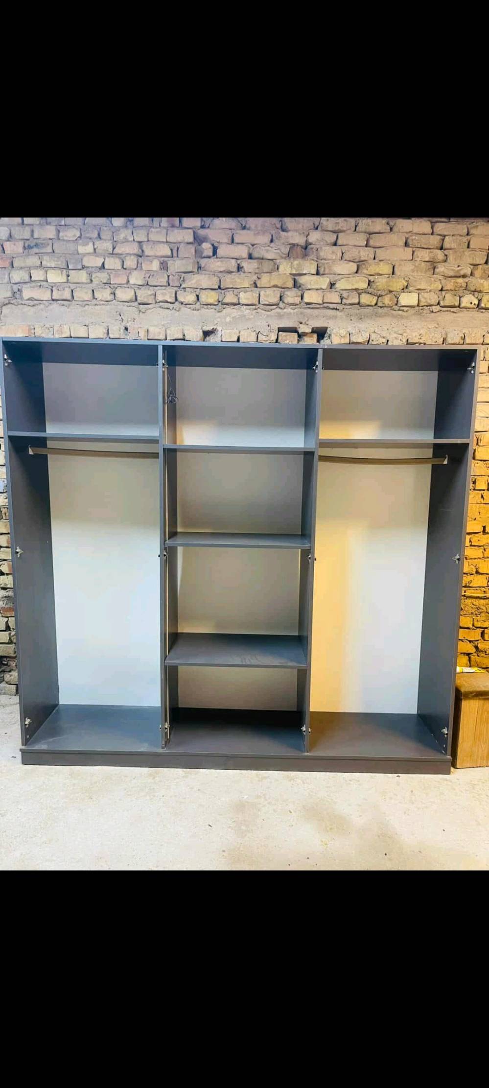 غرفة نوم متكاملة تتضمن خزانة ملابس واسعة بتصميم عصري مع أبواب زجاجية، ودرج بحجم مناسب للتخزين، وتسريحة مع مرآة مميزة. التصميم بسيط وأنيق باللون الرمادي مما يجعله ملائم لجميع الديكورات الداخلية. صنع بدقة عالية لضمان المتانة والجودة.