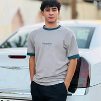 تيشيرت رجالي ستايل كاجوال، لونه رمادي فاتح ويا أطراف كم ويا ياقة باللو...