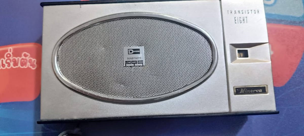 هذا الجهاز هو راديو ترانزستور عتيق (Vintage Transistor Radio)، وتحديداً من طرازات الستينيات.
تفاصيل الجهاز:

العلامة التجارية: يظهر على الجهاز شعار "Minerva"، وهو مشابه في التصميم والخصائص لطرازات أنتجتها شركات مثل Universal و Lloyd's و Showa في تلك الحقبة.

الطراز: يُعرف هذا النوع غالباً باسم "Transistor Eight" لإشارته إلى احتوائه على 8 ترانزستورات، وهو تصميم ياباني كلاسيكي يعود لعام 1962 تقريباً.

المميزات:

يعمل بنظام استقبال موجات AM (MW).

يحتوي على مفتاح للتحكم في الحساسية (Sensitivity) بخيارات: منخفضة، متوسطة، وعالية [صورة المستخدم].

يعمل عادةً ببطاريات من نوع AA. 

يُعد هذا الراديو قطعة نادرة لهواة جمع المقتنيات القديمة ("أنتيك")، حيث كانت هذه الأجهزة أيقونة تكنولوجية في منتصف القرن الماضي.


**إذا كنت صاحب هذا الإعلان وتريد حذفه لأي سبب، رجاءا أرسل رسالة إلى الدعم الفني**