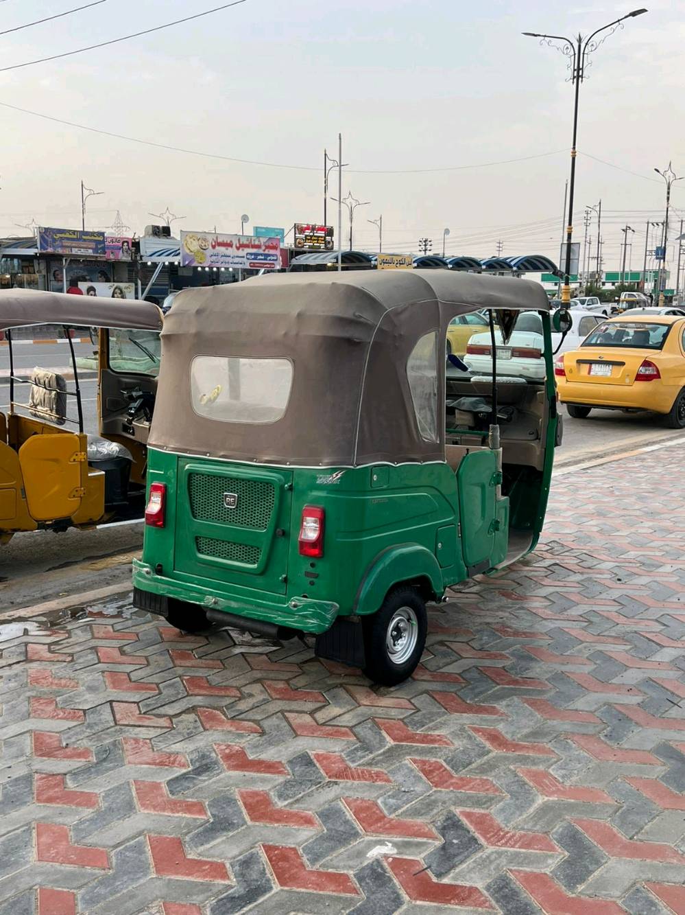 تكتك موديل حديث بلون أخضر، بحالة جيدة ومثالي للتنقل اليومي. يحتوي على كابينة مغطاة لحماية الركاب من العناصر الجوية. مثالي لأعمال التوصيل أو التنقل داخل المدينة.
