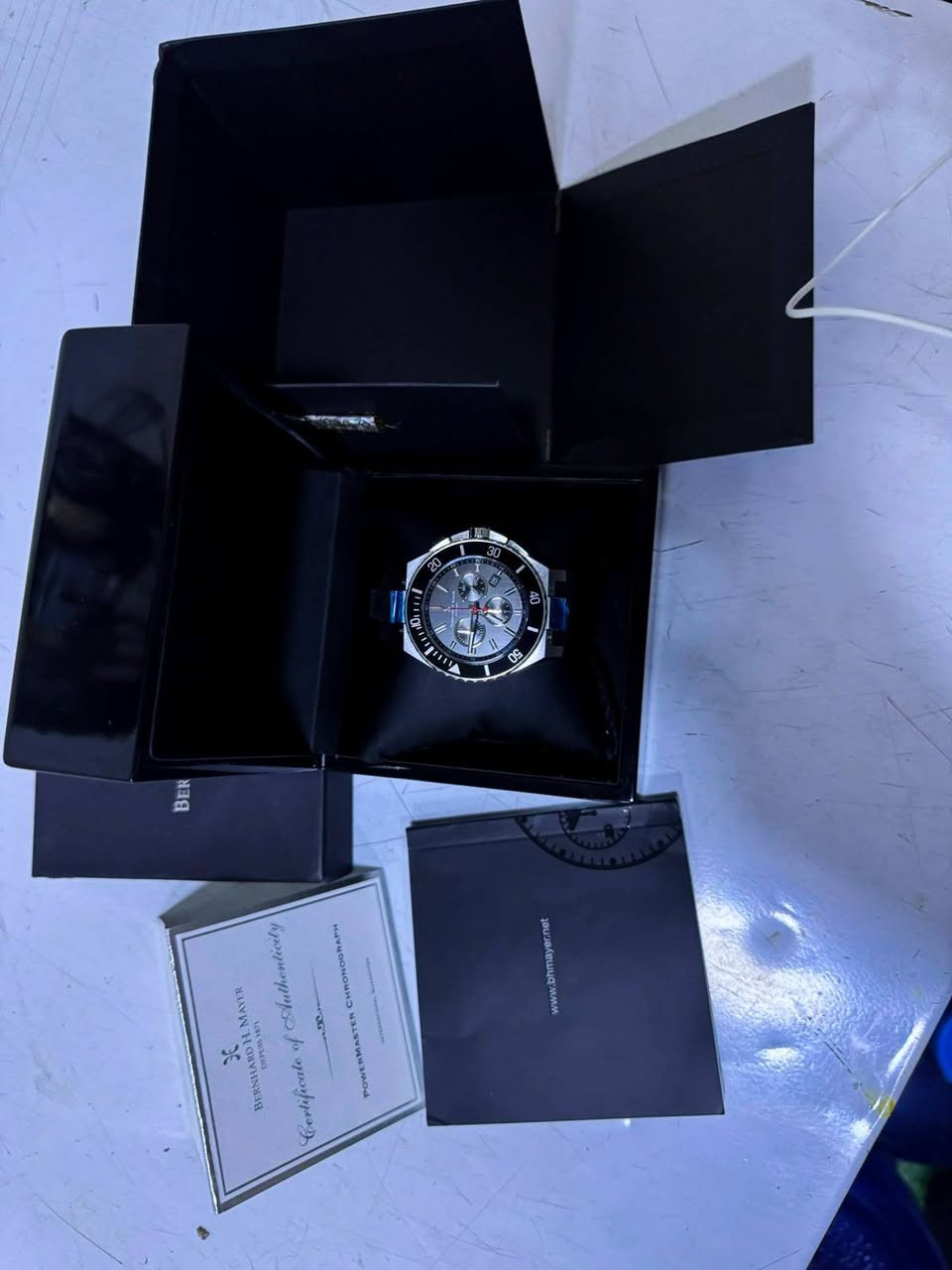العنوان: ساعة Bernhard H. Mayer PowerMaster سويسرية أصلية (كاملة الملحقات)
وصف الإعلان: للبيع ساعة رجالية فاخرة من الماركة السويسرية العريقة Bernhard H. Mayer، موديل PowerMaster Chronograph. الساعة تتميز بتصميم رياضي أنيق ومتانة عالية يوجد معها بطاقة ضمان وسنة صنع ورقم المكنة ساعة 

الحالة: غير مستعملة نظيفة جداً (كما موضح في الفيديو/الصور).

المرفقات: الكارتون الأصلي، علبة الفخامة، دليل المستخدم، وشهادة الأصالة (Certificate of Authenticity).

المواصفات:

صناعة سويسرية (Swiss Made).

زجاج ياقوت (Sapphire Crystal) مقاوم للخدش.

حزام مطاطي (Rubber) طبي أصلي مريح جداً.

نظام كرونوغراف دقيق مع نافذة للتاريخ.

مقاومة للماء حتى عمق 200 متر.

السعر المطلوب: [900$دولار] المكان: [  بغداد - المنصور] للتواصل: [***********]
