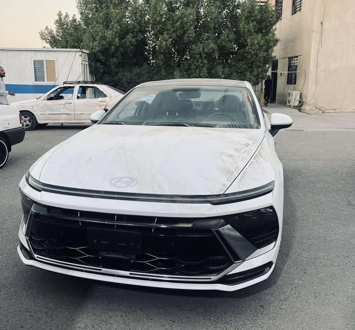 سوناتا 2024  ( خـليـجـي ) بعدها زيرو  بريحه الشركه  كفاله رقم بغداد بسمي عامه ماشيه 9000
الأداء والمحرك (المواصفات القياسية)
• المحرك: 4 أسطوانات (Smartstream) سعة 2.5 لتر.
• القوة الحصانية: حوالي 191 - 194 حصان.
• عزم الدوران: 245 نيوتن متر.
• ناقل الحركة: أوتوماتيكي بـ 8 سرعات.
• نظام الدفع: دفع أمامي (FWD).
• استهلاك الوقود: موفرة جداً، بمعدل تقريبي 16.3 كم/لتر (يختلف قليلاً حسب ظروف القيادة).
2. التصميم الخارجي
• الإضاءة: تتميز بشريط إضاءة LED ممتد في المقدمة يسمى "Seamless Horizon Lamp" يمنحها مظهراً مستقبلياً.
• المصابيح: مصابيح أمامية LED (نوع MFR) وإضاءة خلفية LED متصلة.
• الجنوط: تأتي بقياس 16 أو 17 بوصة من الألمنيوم في الفئة القياسية.
• المرايا: جانبية كهربائية مدمج بها إشارات انعطاف LED.
3. المقصورة والتقنيات الداخلية
• الشاشات: شاشة معلومات وترفيه تعمل باللمس مقاس 12.3 بوصة (أو 8 بوصة في بعض الأسواق لنسخ الفليت)، تدعم Apple CarPlay و Android Auto.
• لوحة العدادات: رقمية بسيطة مقاس 4.2 بوصة LCD تتوسط العدادات التقليدية.
• المقاعد: مكسوة بالقماش عالي الجودة مع تحكم يدوي أو كهربائي بسيط لمقعد السائق.
• التكييف: نظام تكييف هواء يدوي مع فتحات تهوية خلفية.
4. أنظمة السلامة والأمان (Standard)
تتميز سوناتا بأنها توفر حزمة أمان جيدة حتى في أقل فئة:
• وسائد هوائية أمامية مزدوجة (للسائق والراكب).
• نظام تثبيت السرعة (Cruise Control).
• حساسات ركن خلفية للمساعدة في الاصطفاف.
• نظام منع انغلاق المكابح (ABS) وتوزيع قوة الفرامل إلكترونياً (EBD).
• نظام مراقبة ضغط الإطارات (TPMS).
ماشيه9000km 
مكان السياره بغداد 
الاستفسار

‭0771 467 3844‬

