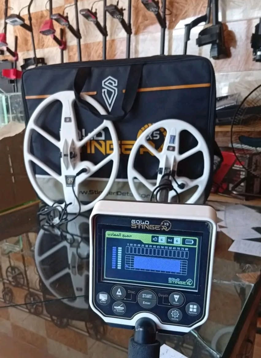 السعر 1000 دولار جهاز جولد ستينجر X5 (Gold Stinger X5) من شركة Stinger Detectors الأمريكية هو جهاز متطور مخصص للكشف عن الذهب الخام، الكنوز المدفونة، الفراغات، والمعادن الثمينة تحت الأرض. يُعد من الأجهزة الصوتية الموثوقة التي تجمع بين سهولة الاستخدام للمبتدئين والميزات المتقدمة للمحترفين. 
المواصفات التقنية الرئيسية
بلد الصنع: الولايات المتحدة الأمريكية.
عمق البحث: يصل إلى 3 أمتار كعمق أقصى (وفي بعض الأهداف الكبيرة قد يصل إلى 5 أمتار).
تردد التشغيل: 17.5 كيلو هرتز (kHz).
قرص البحث: من نوع DD مقاس 11 إنش.
الشاشة: شاشة LCD ملونة بحجم 4.6 بوصة عالية الدقة.
البطارية: ليثيوم بوليمر (Li-Po) تعمل حتى 12 ساعة متواصلة، مع ميزة الشحن السريع (أقل من 4 ساعات).
اللغات: يدعم واجهة مستخدم رسومية متعددة اللغات، بما فيها اللغة العربية.


**إذا كنت صاحب هذا الإعلان وتريد حذفه لأي سبب، رجاءا أرسل رسالة إلى الدعم الفني**