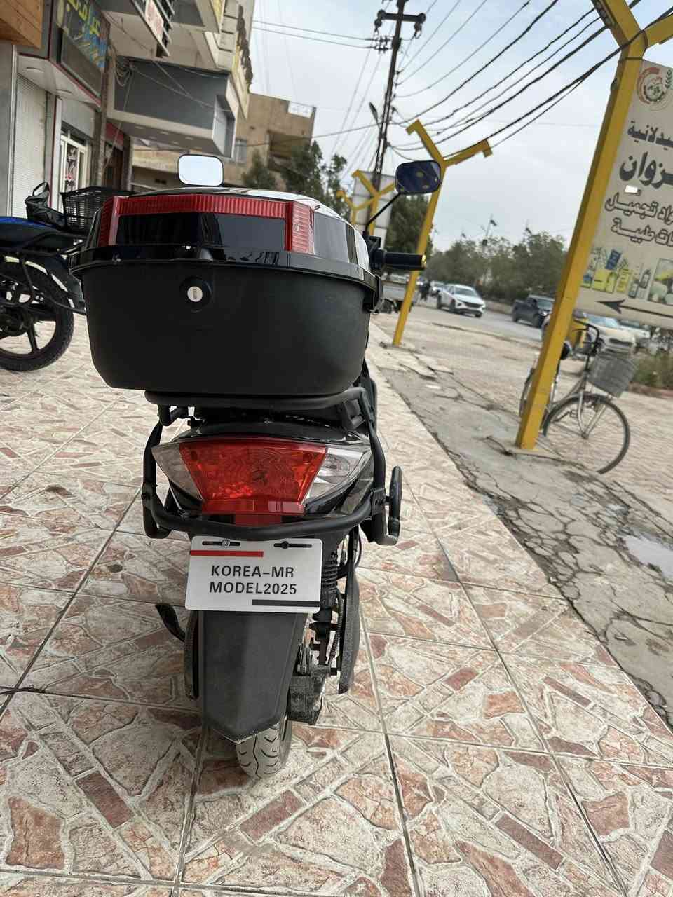 🔹 النوع
سكوتر كهربائي ( KOREA-MR ) 
مناسب للمشاوير القريبة والتنقل اليومي
🔹 التصميم
لون أسود لامع مع خطوط جانبية أنيقة
تصميم انسيابي وشبابي
مرايات جانبية عريضة للرؤية الواضحة
مصباح أمامي كبير LED يعطي إنارة قوية بالليل
مسند قدم واسع ومريح
🔹 المواصفات المتوقعة (تقريبية حسب هذا النوع)
⚡ المحرك: كهربائي (عادة 800 – 1500 واط)
🔋 البطارية: غالبًا رصاص جل
⏱️ الشحن: 6 – 8 ساعات تقريبًا
🚀 السرعة القصوى: 40 – 50 كم/س
📏 المدى: 40 – 60 كم بالشحنة الواحدة
🪑 الحمولة: شخص أو شخصين (حدود 150–180 كغم)
🔹 الأمان والراحة
فرامل أمامية وخلفية
إشارة يمين ويسار.                              ملاحضه موديل 2025
ضوء خلفي + ضوء توقف.                   صارلي شهر من مآخذه 
قاعدة جانبية + وسطية
مقعد مريح وارتفاعه مناسب
🔹 المميزات
ما يحتاج بنزين ⛽
هادئ جدًا
اقتصادي (شحنه أرخص هواي من البنزين)
سهل الاستخدام  تواصل ***********
