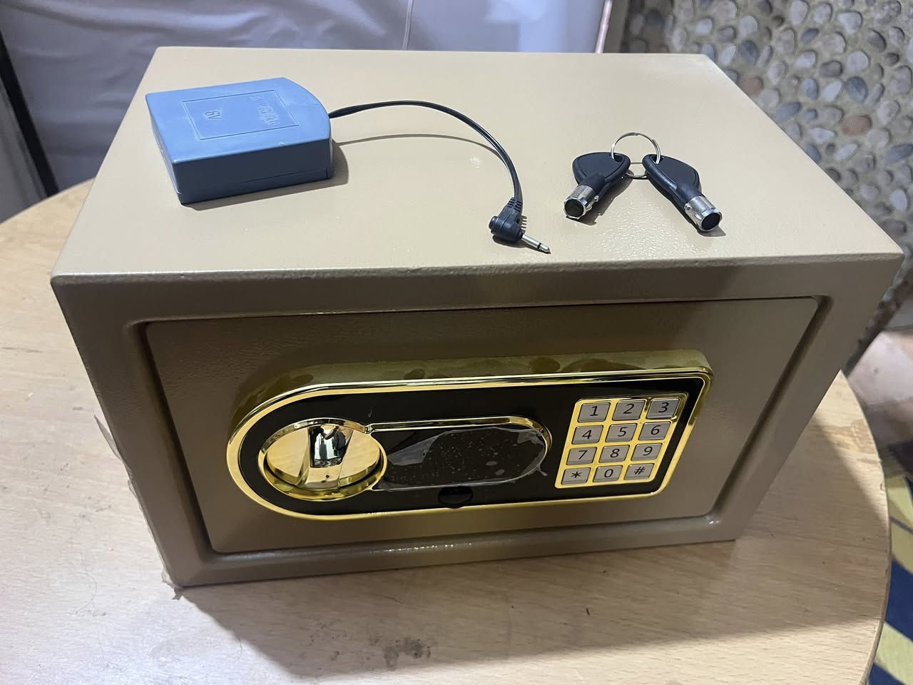 من الصورة يظهر أنها خزنة إلكترونية فندقية/منزلية مستعملة قليلاً قياس صغير–متوسط تعمل برقم سري ولوحة مفاتيح، مع مفتاح طوارئ ووحدة طاقة خارجية للفتح عند نفاد البطارية. هذا النوع شائع في الفنادق والمنازل والمكاتب الصغيرة. سعرها 40 الف 

المواصفات الظاهرة والمتوقعة لهذا النوع الخصائص العامة:
 • نوع القفل: إلكتروني بلوحة أرقام (PIN).
 • فتح طوارئ: بواسطة مفتاحين ميكانيكيين (مرفقين بالصورة).
 • تغذية طاقة خارجية: علبة بطارية خارجية بفيشة 3.5 مم لتغذية الخزنة عند نفاد البطاريات الداخلية.
 • مادة الصنع: فولاذ مطلي، باب أمامي سميك نسبيًا.
 • الاستخدام الشائع: فنادق، شقق مفروشة، منازل، مكاتب.
 • التثبيت: عادةً تحتوي فتحات خلفية/سفلية للتثبيت بالبراغي داخل الخزانة أو الجدار.
 • آلية الإغلاق: مسامير (Bolts) فولاذية جانبية تتحرك كهربائيًا.
 • التشغيل الداخلي: غالبًا 4 بطاريات AA (داخل الباب من الخلف).
 • التنبيه: صفارة عند الإدخال الخاطئ أو انخفاض البطارية.
 • البرمجة: تعيين رقم سري من 3–8 أرقام (يختلف حسب اللوحة).

الأبعاد التقريبية لهذا المقاس:
 • العرض: ~35 سم
 • الارتفاع: ~20 سم
 • العمق: ~20 سم

هذه الأبعاد شائعة جدًا لهذا التصميم.

طريقة الاستخدام الأساسية
 1. إدخال الرقم السري ثم زر # أو * (حسب البرمجة) لفتح.
 2. لتغيير الرقم: فتح الباب → زر Reset الداخلي (خلف الباب) → إدخال الرقم الجديد.
 3. عند نفاد البطارية: توصيل علبة الطاقة الخارجية في الفتحة الأمامية ثم إدخال الرقم.
 4. في حال نسيان الرقم: استخدام مفتاح الطوارئ.

مستوى الأمان
 • مناسب لحفظ نقود، جوازات، مجوهرات خفيفة، مستندات.
 • ليس خزنة بنكية ثقيلة؛ مقاومتها متوسطة ضد الكسر الاحترافي.
 • الأمان يعتمد على تثبيتها جيدًا داخل خزانة/جدار


**إذا كنت صاحب هذا الإعلان وتريد حذفه لأي سبب، رجاءا أرسل رسالة إلى الدعم الفني**