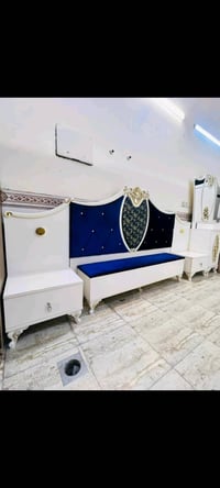 غرفة نوم فاخرة بتصميم كلاسيكي تشمل سرير مريح مع لوح أمامي مبطن باللون ...