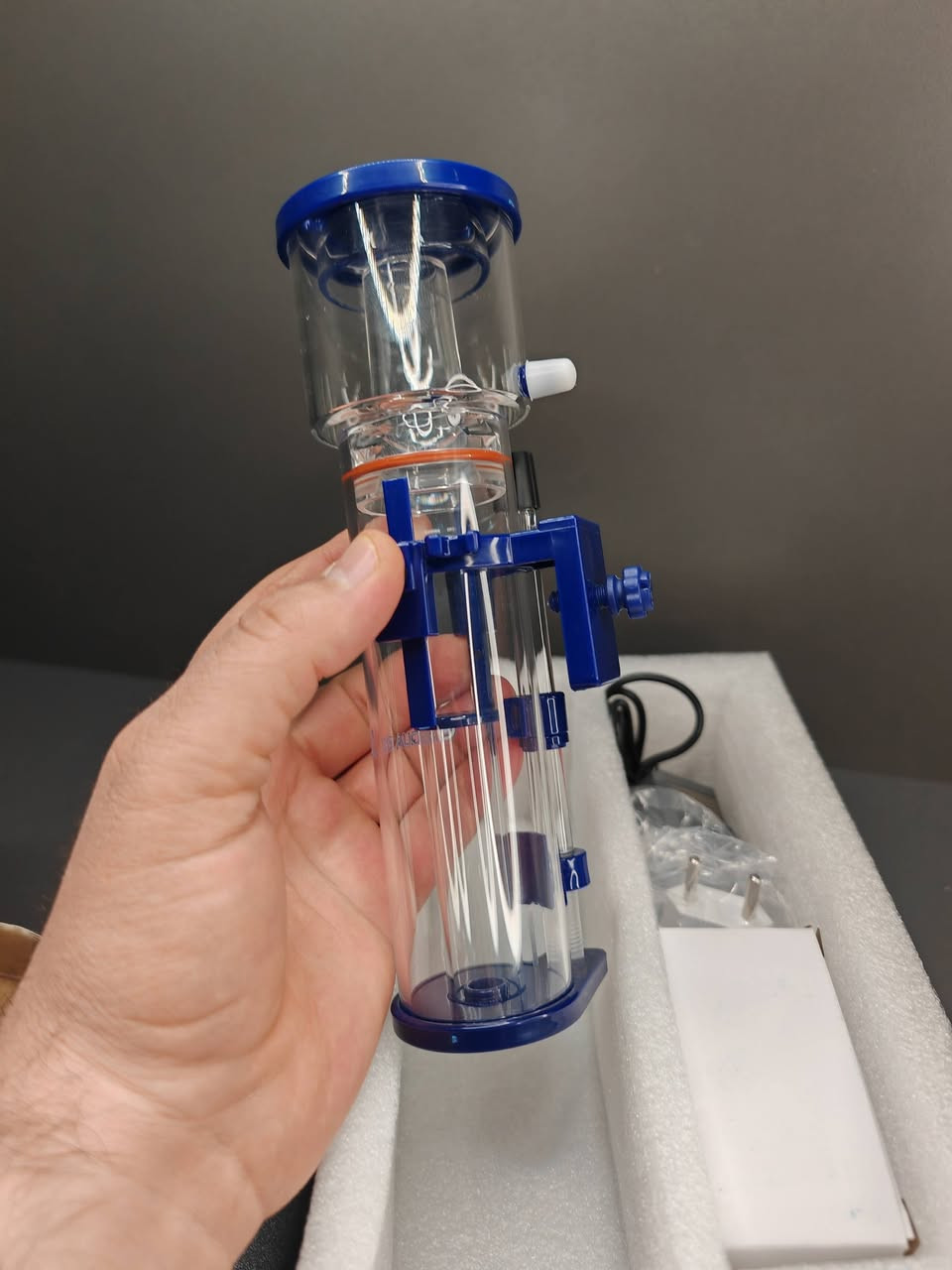 هذا الجهاز هو Protein Skimmer (مقشطة البروتين)، وهو قطعة أساسية ومهمة جداً لأحواض السمك البحرية (المياه المالحة).
إليك شرح مبسط لفائدته وكيفية عمله:
​فائدة الجهاز:
​الوظيفة الأساسية له هي تنظيف المياه من الفضلات العضوية قبل أن تتحلل وتتحول إلى مواد سامة (مثل الأمونيا والنيترات) التي قد تضر الأسماك والمرجان. فهو يعمل كـ "كلية" صناعية للحوض.
​كيفية عمله:
​يعتمد الجهاز على فكرة بسيطة لكنها ذكية جداً:
​خلط الماء بالهواء: يقوم الجهاز بخلط مياه الحوض مع كمية كبيرة من فقاعات الهواء الصغيرة جداً داخل الأنبوب.
​التصاق الأوساخ: الفضلات العضوية والبروتينات الموجودة في الماء تنجذب طبيعياً لفقاعات الهواء وتلتصق بسطحها.
​تكوين الرغوة: ترتفع هذه الفقاعات إلى الأعلى لتشكل رغوة كثيفة (تشبه رغوة الصابون).
​التخلص من الفضلات: تندفع هذه الرغوة إلى الكوب الموجود في أعلى الجهاز (Collection Cup). مع الوقت، تتحول الرغوة إلى سائل داكن اللون وكريه الرائحة يتم تنظيفه يدوياً لاحقاً.
​لماذا هو مهم؟
​صفاء المياه: يساعد في جعل الماء صافياً جداً.
​زيادة الأكسجين: عملية خلط الهواء بالماء تزيد من نسبة الأكسجين المذاب، وهو أمر ضروري لصحة الأسماك.
​تقليل التغييرات المتكررة للماء: لأنه يزيل الفضلات بكفاءة، فإنه يقلل العبء على الفلاتر الأخرى.
​ملاحظة: هذا الموديل الموضح في الصورة (AE-NANO 40D) مصمم خصيصاً للأحواض الصغيرة (Nano Tanks) ويتميز بحجمه المدمج وسهولة تركيبه


**إذا كنت صاحب هذا الإعلان وتريد حذفه لأي سبب، رجاءا أرسل رسالة إلى الدعم الفني**