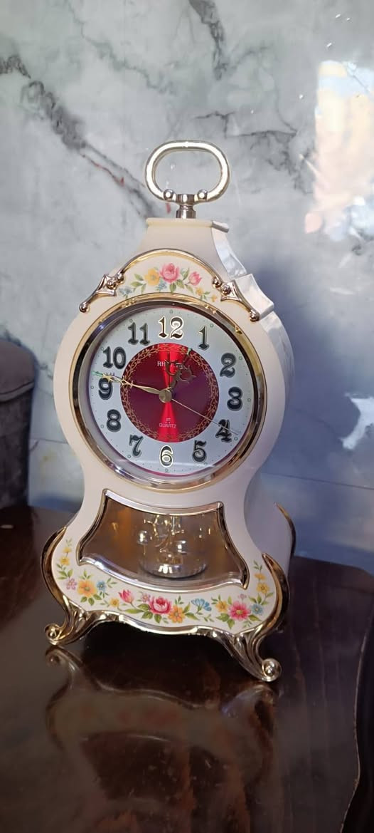 ساعة مكتبية كلاسيكية أنتيك (Mantle Clock) من إنتاج ماركة ريذم (Rhythm) أو سيتيزن (Citizen) اليابانية. تم تصميمها على الطراز الأوروبي الفاخر المستوحى من ساعات نيوستيل (Neuchâtel) السويسرية الشهيرة. [1, 2, 3

‫ ساعة مكتبية كلاسيكية أنتيك (Mantle Clock) من إنتاج ماركة ريذم (Rhythm) أو سيتيزن (Citizen) اليابانية. تم تصميمها على الطراز الأوروبي الفاخر المستوحى من ساعات نيوستيل (Neuchâtel) السويسرية الشهيرة. 
المواصفات والتصميم
الهيكل: يأتي بلون كريمي (أوف وايت) أنيق مصنوع من الراتنج أو البلاستيك المقوى عالي الجودة.
الزخارف: مزينة بنقوش زهور ملونة وجميلة (Floral Design) مع إطارات وقوائم ذهبية كلاسيكية تمنحها مظهرًا ملكيًا.
الميناء: قلب الميناء يأتي بلون أحمر غني (عنابي) مع أرقام سوداء واضحة وعقارب ذهبية.
البندول: تحتوي في جزئها السفلي خلف الزجاج على بندول ذهبي دوّار يضفي حركة ميكانيكية ساحرة.
المزايا: تعمل بنظام الكوارتز الدقيق (Quartz)، وتشتهر باحتوائها على منبه موسيقي يعزف ألحانًا ونغمات متعددة. 

I


**إذا كنت صاحب هذا الإعلان وتريد حذفه لأي سبب، رجاءا أرسل رسالة إلى الدعم الفني**