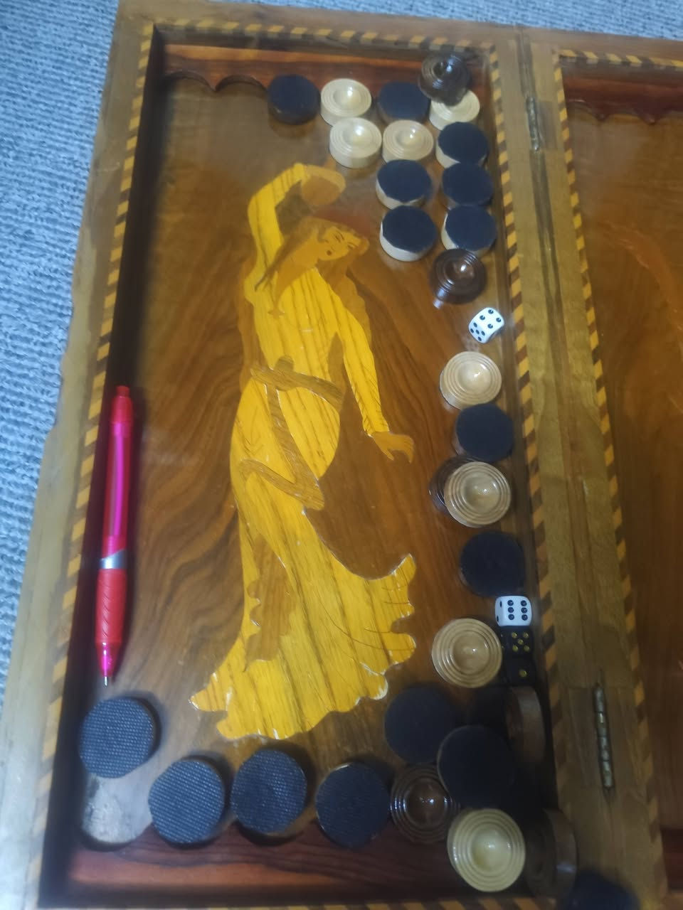 طاولة زهر (Backgammon) خشبية تقليدية مزخرفة بفن "الخاتم" أو "الماركتري" الإيراني، والذي يتضمن تطعيم الخشب بقطع صغيرة من مواد أخرى. السعر 75 الطلب على الواتساب ***********
