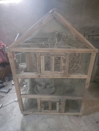 هذا قفص خشبي للطيور مصمم بشكل جذاب، يمكن استخدامه داخل المنزل أو في ال...