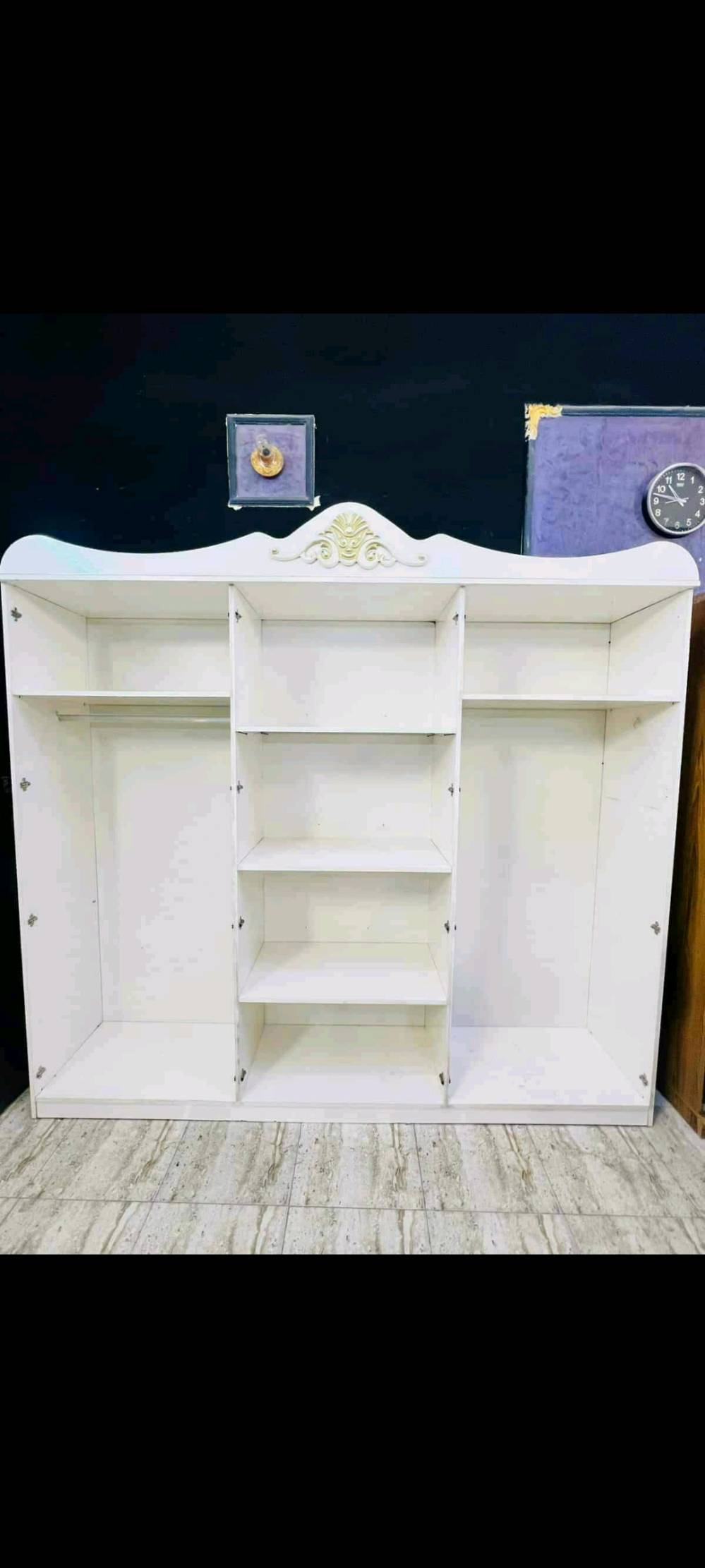 غرفة نوم فخمة للبيع بحالة ممتازة، تتضمن تسريحة بتصميم كلاسيكي مع مرآة كبيرة وأدراج تخزين، سرير مريح بتنجيد فاخر باللون الأزرق الداكن، خزانة راقية بتفاصيل ذهبية، وكمودينات جانبية. التصميم يضيف لمسة من الجمال الكلاسيكي لأي غرفة.