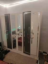 غرفة نوم فاخرة بحالة ممتازة، تشمل سرير كبير مريح بخلفية مضيئة ومزينة، ...