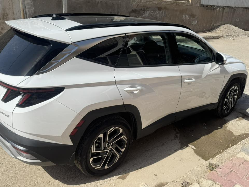 2025 Tucson limited هايبرد
توسان لمتد اعلى مواصفات
السيارة جديدة ودخول جديد واخت الزيرو بعدها 
ماشية 3000ميل 
محرك 1600 توربو هايبرد 
بانوراما 
اربع كامرات امامي وخلفية وجانبية بالمرايات 
 حساسات امامية وخلفية ١٢ حساس
رادار امامي وجانبي وخلفي نقط عمياء 
تتقدم وترجع بالبصمة 
كشنات جلد اسود وكهرباء الاماميات 
تبريد وتدفئة كشنات امامية وستيرن تدفئة وكشنات خلفية تدفئة 
كشن السائق ميموري 
كير تعليك و شفتات ستيرن 
صندوق كهرباء ومن تقترب منة يفتح  
 داتا شو تعرض على الجامة الامامية 
سستم صوت Bose مع دمام بالصندوق
اوتو هولد
 مساعدة النزول من المنحدرات 
شاحن تلبفون واير ليس 
حساس قراءة العين 
الوان داخلية تتغير ١٠ الوان بيها 
ويل كب حجم ١٩ 
 شاشة كبيرة ابل كار بلي واندرويد اوتو 
السيارة جديدة ومابيها اي نقص 
حادثها جاملوغ وبنيد ومبدلهن بلادي يعني بدون صبغ 
مكان السيارة بعقوبة
***********
