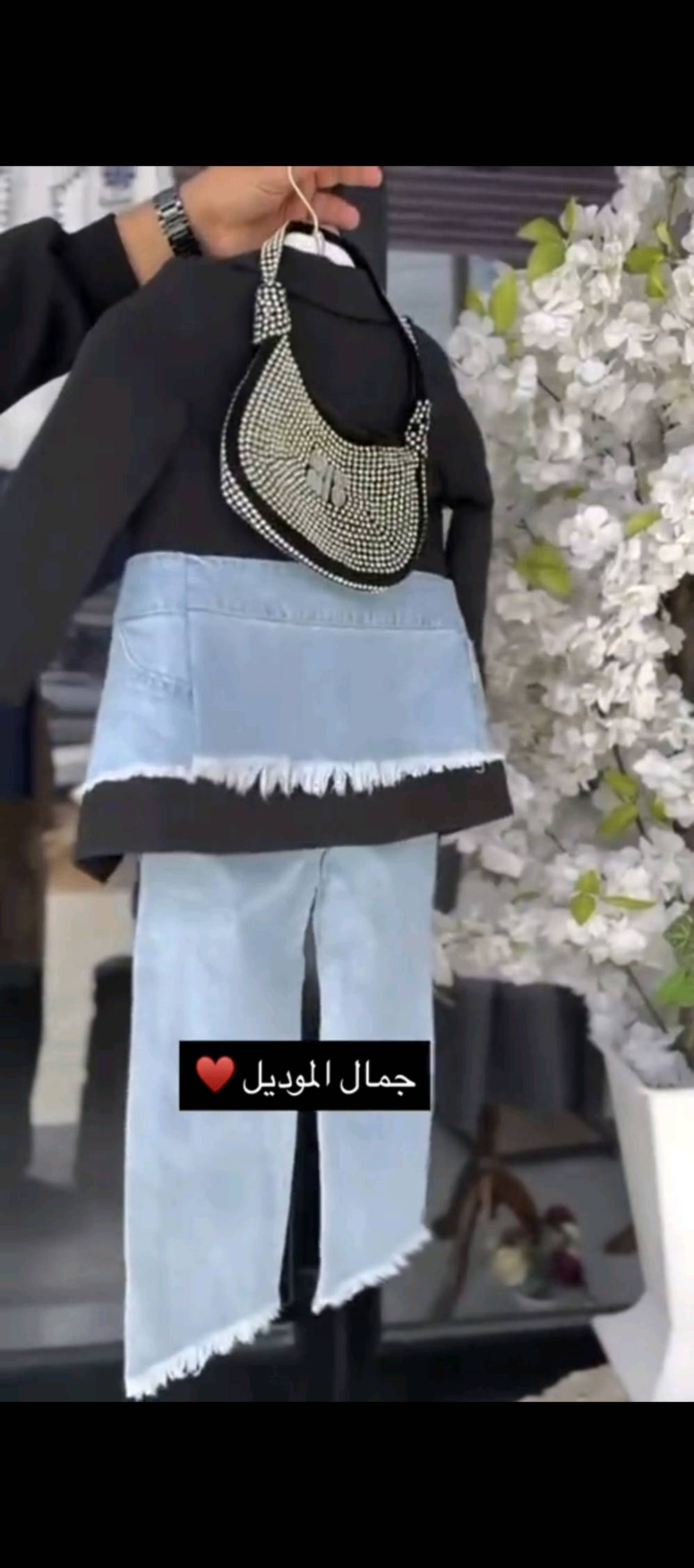 هذا الطقم المميز مكون من بنطلون جينز أزرق فاتح مرصع، وحزام أنيق يضيف لمسة عصرية. يتكون الجزء العلوي من بلوزة سوداء بشعار أنيق عليه، وجاكيت بتصميم عصري يضم تفاصيل بجيوب جينزية ذات أطراف ممزقة لإطلالة رائعة ومتميزة. مثالي لمناسباتك الخاصة ولمظهر فريد يعكس ثقتك بنفسك.

