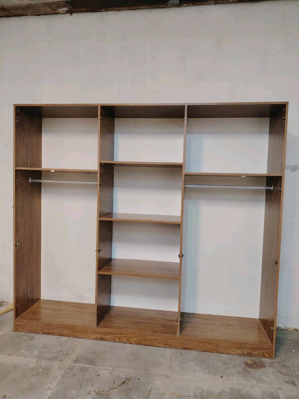 مجموعة غرفة نوم جديدة تحتوي على خزانات واسعة ومرآة وطاولة زينة مصنوعة من خشب متين. التصميم يجمع بين الأناقة والخطوط العصرية مع لمسات كلاسيكية. مثالية لإضفاء لمسة جمالية على غرفة النوم.