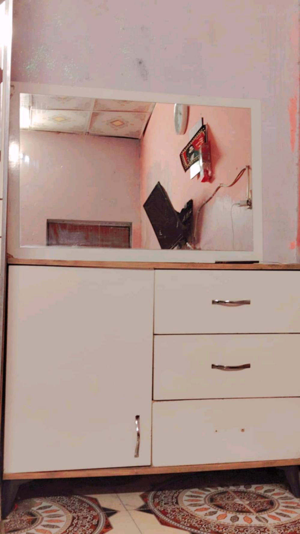 غرفة نوم متكاملة تشمل سرير بحجم متوسط ودولاب خشبي مع مرآة كبيرة. التصميم يجمع بين اللونين الأبيض والخشبي مما يضفي مظهراً عصرياً وأنيقاً على الغرفة. مثالية للاستخدام اليومي وحالتها جيدة جداً.