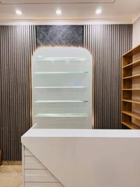 ميز كاشير أبيض • رفوف زجاج إنارة • رف خشب ٤م