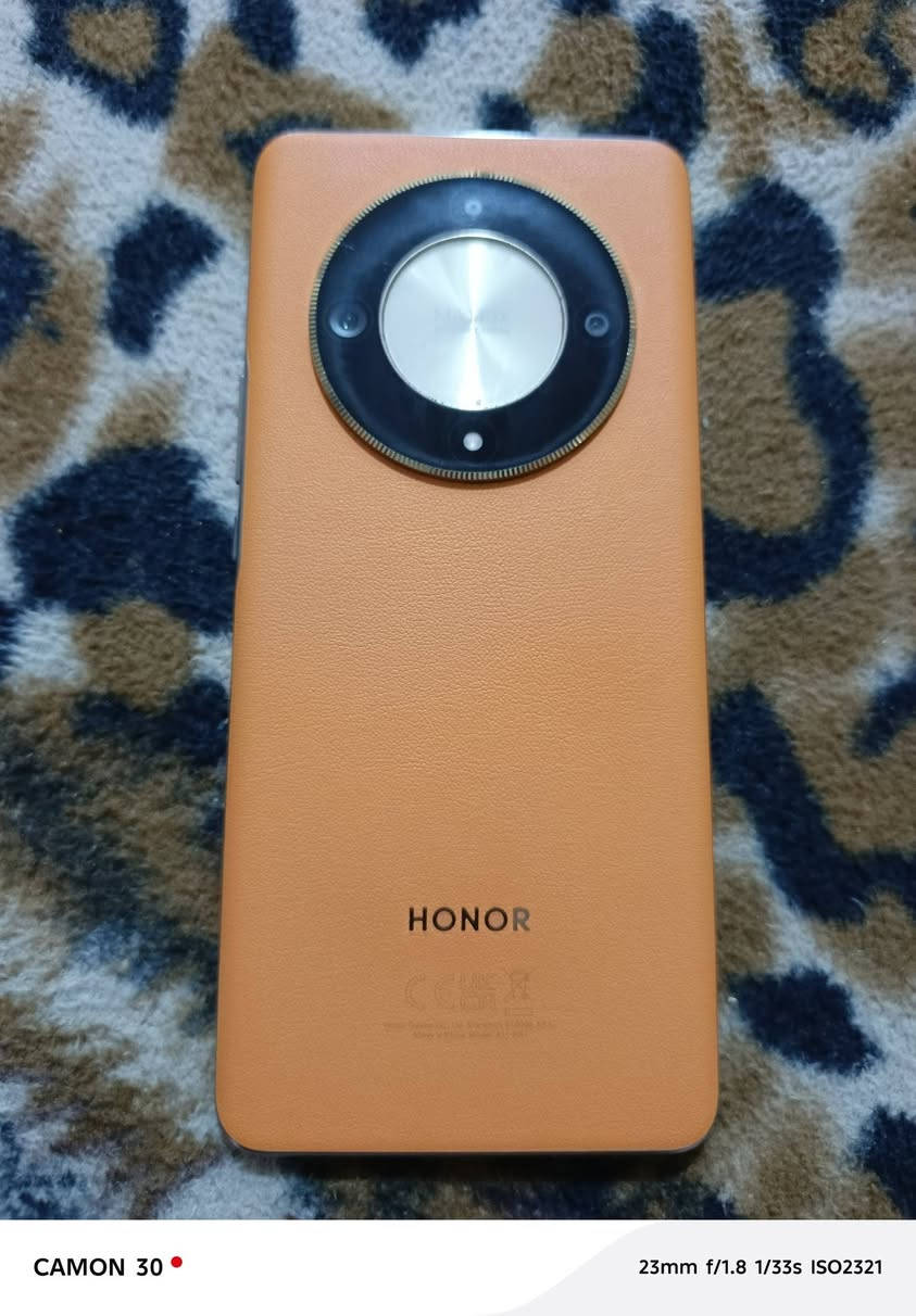 ‏ هاتف HONOR X9b 5G (ويعرف برقم الموديل ALI-NX1)، ويأتي باللون البرتقالي المميز المصنوع من الجلد النباتي (Sunrise Orange).
‏​إليك نظرة سريعة على أهم المواصفات التقنية لهذا الهاتف:
‏​📱 الشاشة والتصميم
‏​الشاشة: شاشة منحنية من نوع AMOLED بحجم 6.78 بوصة، وبدقة 1200 \times 2652 بكسل وتردد 120 هرتز.
‏​ميزة المقاومة: تتميز هذه الشاشة بتقنية HONOR Ultra-Bounce لمقاومة الصدمات والسقوط، وهي من أبرز نقاط البيع لهذا الهاتف.
‏​الخلفية: جلد صناعي (ملمس جلدي) مريح لليد ومقاوم للبصمات.
‏​⚙️ الأداء والعتاد الداخلي
‏​المعالج: Qualcomm Snapdragon 6 Gen 1 بدقة تصنيع 4 نانومتر.
‏​الذاكرة العشوائية (RAM): يأتي غالباً بـ 12 جيجابايت (مع إمكانية توسيعها افتراضياً عبر النظام).
‏​ذاكرة التخزين: 256 جيجابايت 
‏​📸 منظومة الكاميرات
‏​يحتوي الإطار الدائري الكبير في الخلف على كاميرا ثلاثية:
‏​الكاميرا الأساسية: بدقة 108 ميجابكسل بفتحة عدسة f/1.8.
‏​الكاميرا الواسعة (Ultrawide): بدقة 5 ميجابكسل.
‏​كاميرا الماكرو: بدقة 2 ميجابكسل.
‏​الكاميرا الأمامية: بدقة 16 ميجابكسل متواجدة في ثقب منتصف الشاشة.
‏​🔋 البطارية والشحن
‏​السعة: بطارية ضخمة جداً بسعة 5800 مللي أمبير، وهي من أقوى البطاريات في فئتها السعرية وتكفي للاستخدام المكثف بسهولة.
‏​سرعة الشحن: يدعم الشحن السريع بقوة 35 واط عبر منفذ USB Type-C.
‏  الجهاز لا مفتوح ولا مصلح السعر 250


**إذا كنت صاحب هذا الإعلان وتريد حذفه لأي سبب، رجاءا أرسل رسالة إلى الدعم الفني**