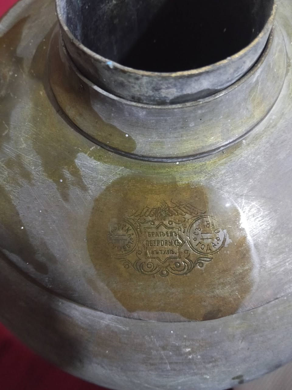 للبيع مكان النجف اي ستفسار اتصال ***********
هذا سماور عتيق (Samovar) مصنوع من النحاس أو النيكل، ويشبه طرازات إنجليزية من القرن التاسع عشر.
يتميز القطعة بشكل كروي (شكل "شمعة") ومقابض مزخرفة على شكل أسد.
تستخدم هذه الأوعية تقليديًا لغلي الماء وتحضير الشاي.
قد تكون هذه القطعة  كعنصر عتيق
الختم الواضح في الصورة مكتوب باللغة الروسية القديمة (قبل الثورة) ويعود إلى مصنع الأخوة بيتروف في مدينة تولا الروسية (БРАТЬЕВЪ ПЕТРОВЫХЪ ВЪ ТУЛЕ). 
إليك تفاصيل هذا الختم التاريخي:
اسم الصانع: مصنع الأخوة بيتروف (Братья Петровы).
مكان الصنع: مدينة تولا الروسية، وهي العاصمة التاريخية والأشهر عالمياً في صناعة سماورات الفحم النحاسية.
الفترة الزمنية: يعود هذا الختم إلى القرن التاسع عشر (تأسس المصنع قرابة عام 1850)، وتحديداً في الفترة القيصرية، نظراً لرسم النسر الإمبراطوري الروسي والخط المستخدم في صك الختم. 

Самовары.Ком
 +3
وجود مثل هذا الختم الإمبراطوري يؤكد أصالة القطعة كتحفة روسية أثرية نادرة وليس مجرد تقليد أجنبي. 
إذا كنت مهتماً، هل ترغب في معرفة القيمة السوقية التقريبية الحالية لسماورات هذا المصنع الروسي
