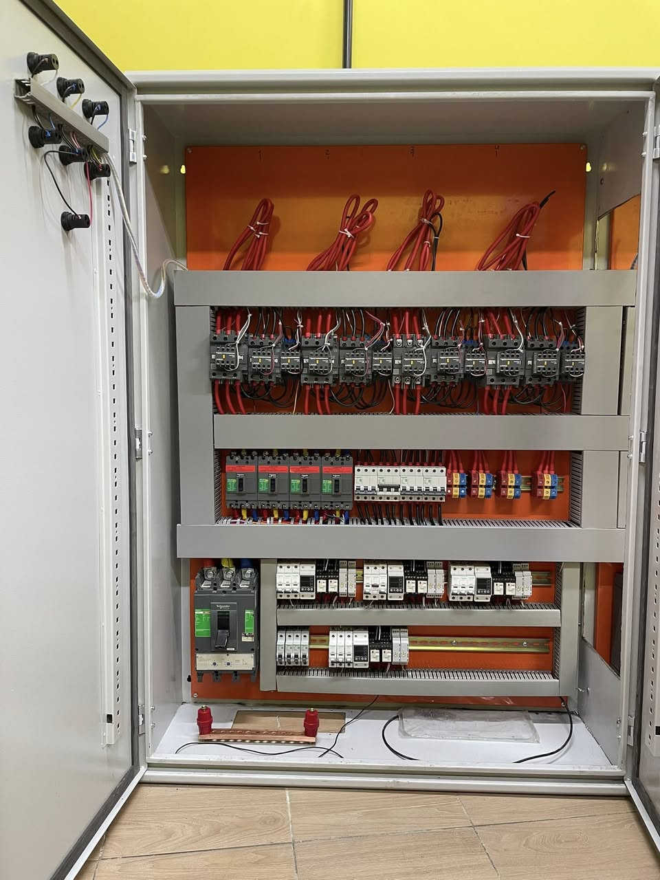 عندما تتحول موثوقية الطاقة إلى معيار هندسي مُحكم و ليس مجرد قرار تجاري عابر..

في المشاريع السكنية الحديثة ، إدارة الطاقة ليست مجرد تغذية كهربائية ، بل منظومة متكاملة من الاعتمادية ، السلامة ، و دقة القياس.
بتوفيق الله ، قمنا بتصميم و تصنيع لوحة تحويل تلقائي (Automatic Transfer Switch – ATS) متقدمة ، تعتمد على حلول Schneider Electric ، لتخدم عمارة سكنية مكونة من 7 وحدات مستقلة ، مع نظام تحويل آلي منفصل (Independent Automatic Transfer System) لكل شقة ، وفق أفضل الممارسات الهندسية العالمية.

⚡ البنية الهندسية للنظام | المواصفات الفنية : 
- تم تصميم و تنفيذ لوحة تحويل تلقائي (Automatic Transfer Switch – ATS) بهيكلية هندسية مدروسة و بأبعاد 200 × 140 سم ، قادرة على استيعاب الأحمال العالية مع ضمان توزيع طاقة متوازن (Balanced Load Distribution) و استقرار تشغيلي طويل الأمد.
- تعتمد المنظومة على مصدرَي تغذية رئيسيين : 
❶ مصدر الشبكة الوطنية (Utility Power Source) 
❷ مصدر المولد الاحتياطي (Backup Generator Source)
وذلك عبر قاطعَي دخول رئيسيين بسعة (400A) لضمان موثوقية التحويل و استمرارية التغذية.
- منظومة تحويل مستقلة : تم اعتماد نظام تحويل آلي مستقل (Independent Automatic Transfer System) لكل شقة من خلال لوحة ATS منفصلة تضمن الفصل الكامل بين الوحدات السكنية (إدارة الطاقة لكل شقة بشكل مستقل) ، و تتكون كل لوحة ATS من خمسة مكونات رئيسية :
❶ قاطع دخول رئيسي (MCCB 100A)
❷ قاطع حماية ثلاثي (MCB 63A)
❸ كونتكتر رئيسي (Main Contactor 125A)
❹ كونتكتر تحويل (Transfer Contactor 80A)
❺ كونتكتر خط السحب (Load Shedding Contactor 25A)
- فلسفة الحماية و التحكم : تم تطوير منظومة الحماية و التحكم وفق فلسفة هندسية مدروسة ، تهدف إلى ضمان استقرار النظام الكهربائي و حماية الأحمال و منع أي تداخل غير مرغوب بين مصادر التغذية ، و ابرز مكونات الرئيسية هي :
❶ جهاز حماية الجهد الكهربائي 
(Over / Under Voltage Protection Relay)
❷ مؤقت زمني (2 × Time Delay Relays) للتحكم بتسلسل التحويل و تقليل الصدمات الكهربائية و منع التداخل بين مصادر التغذية.

⚡ القيمة التشغيلية | الفوائد المحققة :
• حماية شاملة للأحمال من تيار الحمل الزائد (Overload Current) و تيار القصر الكهربائي (Short Circuit Current) عبر منظومة القواطع الرئيسية و الفرعية ، بما يضمن الفصل الفوري للأعطال و منع ارتفاع درجات الحرارة أو تلف المكونات.
• حماية الجهد الكهربائي من الارتفاع و الانخفاض (Over / Under Voltage Protection) فيما يخص الشبكة الوطنية ، لمنع تلف الأجهزة الحساسة الناتج عن عدم استقرار الفولتية.
• منع التداخل بين مصادر التغذية (Source Interlocking Protection) مع حماية الأحمال أثناء التحويل عبر تسلسل زمني مدروس (Time Delay Transfer Logic) بأستخدام تايمرات زمنية (Time Delay Relays) ، بما يضمن عدم تزامن الشبكة الوطنية مع المولد و تقليل الصدمات الكهربائية أثناء الانتقال بين المصادر.
• يوفر النظام فصل كامل للأحمال بين الوحدات السكنية عبر نظام تحويل مستقل (Independent ATS System) ، مما يمنع انتقال الأعطال بين الشقق ، و يتيح قياس استهلاك الطاقة لكل شقة بدقة عالية ، مع الامتثال الكامل لمتطلبات السلامة التشغيلية العامة للمباني السكنية متعددة الوحدات.

⚡ مجالات التطبيق | الاستخدامات :
• المجمعات السكنية.  
• الأبنية الاستثمارية.
• المباني المعتمدة على أنظمة مولدات احتياطية.
• المشاريع التي تتطلب أنظمة (ATS) مستقلة مع قياس استهلاك طاقة دقيق.

في #عصر_الأتمتة ، نعمل برسالة هندسية ، لا بغاية ربحية..

⚡ نفتخر بتقديم حلولاً مبتكرة في تصميم و تصنيع اللوحات الكهربائية للمشاريع السكنية و الصناعية ، مع ضمان جودة يؤكد التزامنا الصارم بالمواصفات الأوروبية في كل تفصيلة ، حيث أن جميع لوحاتنا مطابقة لمعايير IEC 61439 و IEC 60947 و معتمدة بعلامة CE الأوروبية ، لضمان أعلى مستويات السلامة و الاعتمادية ، كما نُؤكد علىٰ عدم تعاملنا بالمواد الغير اصلية (المقلدة) حتى لو كان ذلك بطلب من العميل نفسه !
⚡ خدماتنا تشمل :
• دعم فني حقيقي مقدم من فريق مُهندسين عالي المهارة.
• توصيل مباشر الى الموقع مع تركيب احترافي.
• صيانة موقعية موثوقة.
• توفير قطع غيار اصلية.

قسم التصميم (اتصال + واتساب) : ‭0787 980 1800‬
الدعم الفني :
eng.hussein_qasim_kadhim@yahoo.com
الادارة : automation.era@yahoo.com
العنوان : بغداد / الشورجة / عكد النصارى / قرب مطعم العمار

#لوحات_التحويل_التلقائي
#لوحات_توزيع_رئيسية
#أنظمة_الطاقة_السكنية  
#أنظمة_قدرة_موثوقة 
#حلول_كهربائية_متقدمة 
#شنايدر_الكتريك 
#ATSPanel 
#MDBPanel
#SmartElectricalBoards 
#ResidentialPowerSystems 
#AutomaticEnergyControl 
#LoadProtectionSolutions 
#BackupPowerManagement 
#ReliableEnergyDistribution
