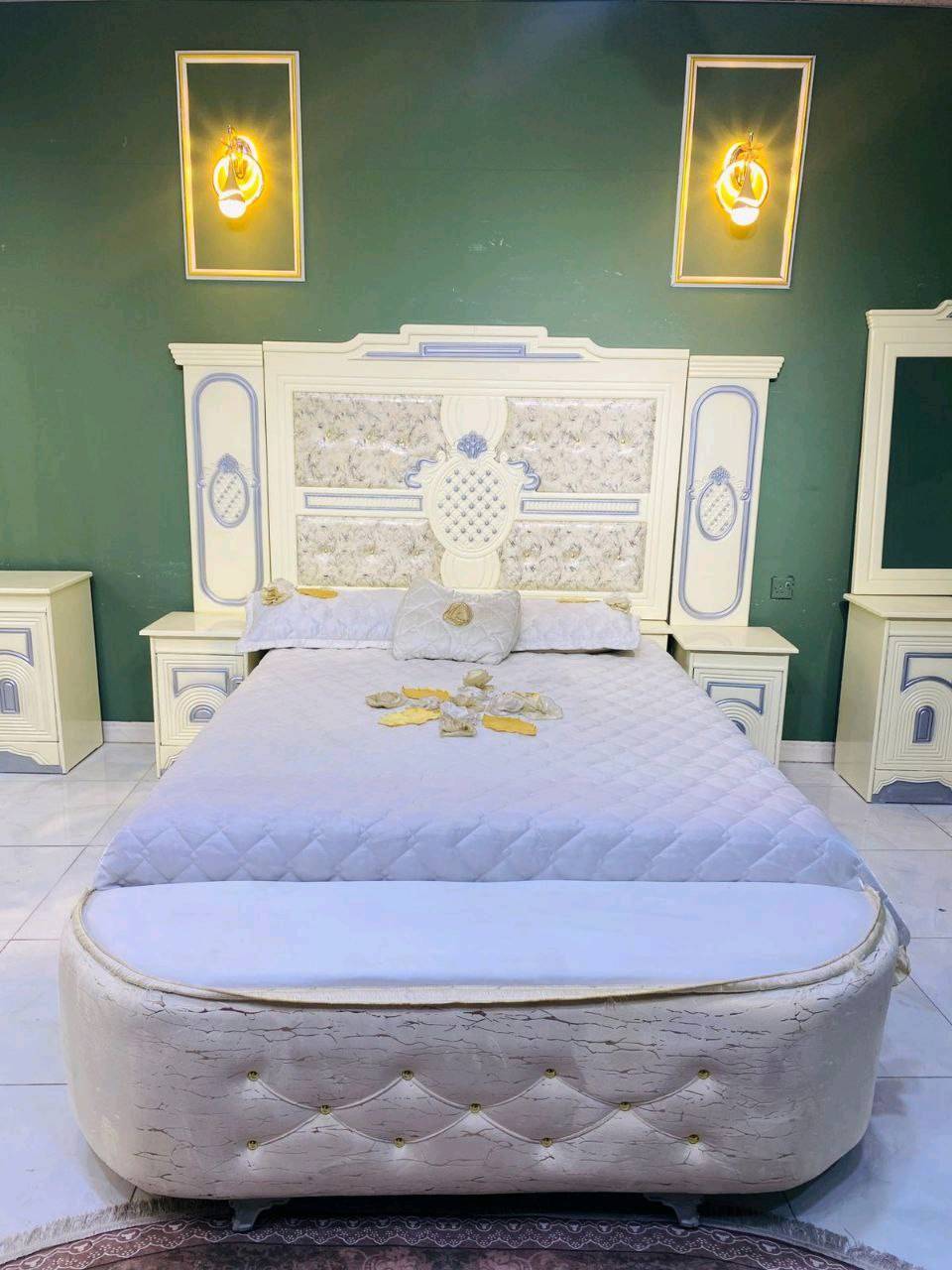 غرفة نوم فاخرة بتصميم كلاسيكي جذاب تتميز بمظهر أنيق وفخم. تضم سرير واسع ودولاب ملابس كبير مع مرايا، بالإضافة إلى طاولة زينة ودواليب جانبية بنفس التصميم. الخامات المستخدمة تعطي مظهر دافئ ومريح، مثالي لإضفاء لمسة من الفخامة في غرفة نومك.