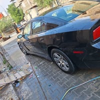 السيارة المعروضة هي دودج تشارجر اللون أسود، بحالة جيدة من الخارج والدا...