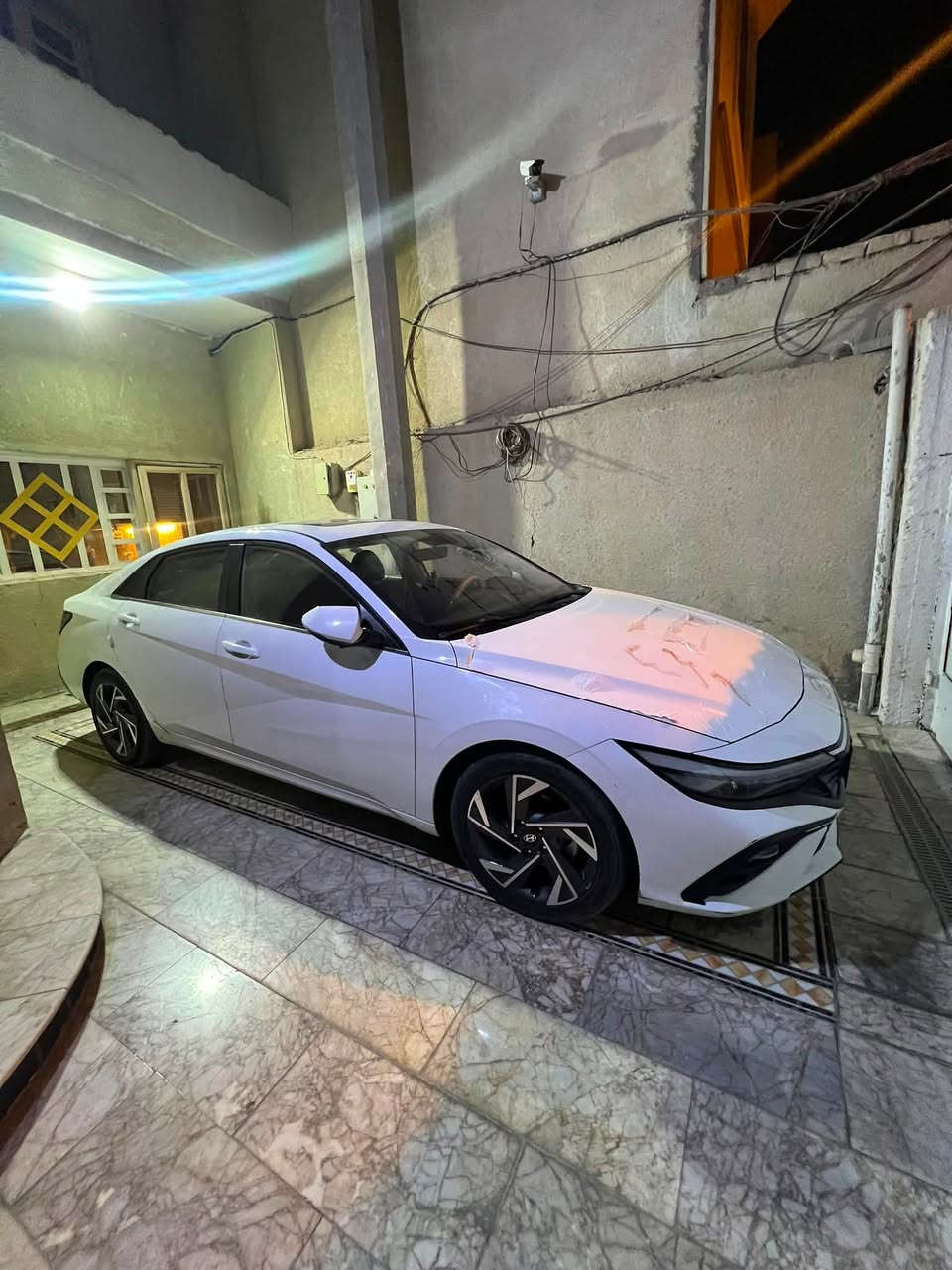 السلام عليكم
النترا تجميع الصين 
*مواصفات Hyundai Elantra 2024 - 1.5L الصين*

*1. المحرك والقوة*
- *المحرك*: 1.5 لتر بنزين 4 سلندر تنفس طبيعي
- *القوة*: 115 حصان @ 6300rpm
- *العزم*: 143.9 نيوتن.م @ 4500rpm
- *الوقود*: بنزين

*2. الكير والدفع*
- *الكير*: CVT مستمر التغيير
- *الدفع*: امامي
- *انماط القيادة*: رياضي, اقتصادي, عادي

*3. الابعاد*
- *الطول × العرض × الارتفاع*: 4720 × 1810 × 1415 ملم
- *قاعدة العجلات*: 2720 ملم
- *سعة خزان الوقود*: 47 لتر
- *سعة الصندوق الخلفي*: 474 لتر

*4. التعليق والفرامل والتايرات*
- *التعليق الامامي*: MacPherson مستقل
- *التعليق الخلفي*: Multi-Link مستقل
- *الفرامل الامامية*: دسك مهوى
- *الفرامل الخلفية*: دسك
- *بريك اليد*: الكتروني EPB
- *قياس التايرات*: 225/45 R17
- *الجنط*: المنيوم

*5. الامان*
- *الايرباك*: امامي + جانبي امامي + ستائر امامي وخلفي
- *انظمة*: ABS, EBD, BA, TCS, ESC
- *تحذير مغادرة المسار LDWS*: موجود
- *حساسات بارك امامي وخلفي*: موجودة
- *كاميرا خلفية*: موجودة
- *مراقبة ضغط الاطارات*: موجود
- *تثبيت كراسي اطفال ISOFIX*: موجود

*6. الداخلية والتكنولوجيا*
- *الشاشة الوسطية*: 8 انش لمس
- *دعم الموبايل*: CarPlay / CarLife / HiCar
- *المقود*: جلد + متعدد الوظائف
- *التكييف*: يدوي + فتحات خلفية
- *المقاعد*: جلد + تعديل كهربائي
- *تشغيل عن بعد + دخول بصمة*: موجود

*7. الخارجية*
- *الاضاءة*: LED امامي وخلفي
- *النهاري DRL*: موجود
- *فتحة السقف*: كهربائية
- *المرايا*: كهربائية + طي كهربائي + تطوي عند القفل
- *فتح الصندوق*: حساس بالقدم

*8. اضافات*
- *Auto Hold*: موجود
- *مساعد صعود المرتفعات*: موجود
- *نظام Bluelink*: موجود

رقم اربيل الجديد 
بـ اسم ولد عربي بيتهم بـ البصرة 
تريد تحويل تريد وكاله الولد حاظر 
ماشيه 74 الف قابل للـ زياده 
السيارة فول فتحه سقف ومعروفه مراصفات الصيني بـ الفول 
السيارة جاهزه كاملة ما تصرف عليها ربع دينار 
السياره بيها خسفه ب البنيد مثل ما موضح بـ الصور 
السيارة موجود بيها ويل الكب مالتها جديد نضيف ما ماشي علية موجوده صور الها بـ الويل كب 
حالياً شادلها رنكات 

السعر 135 قابل للـ تفاوض 

للاستفسار : ***********
