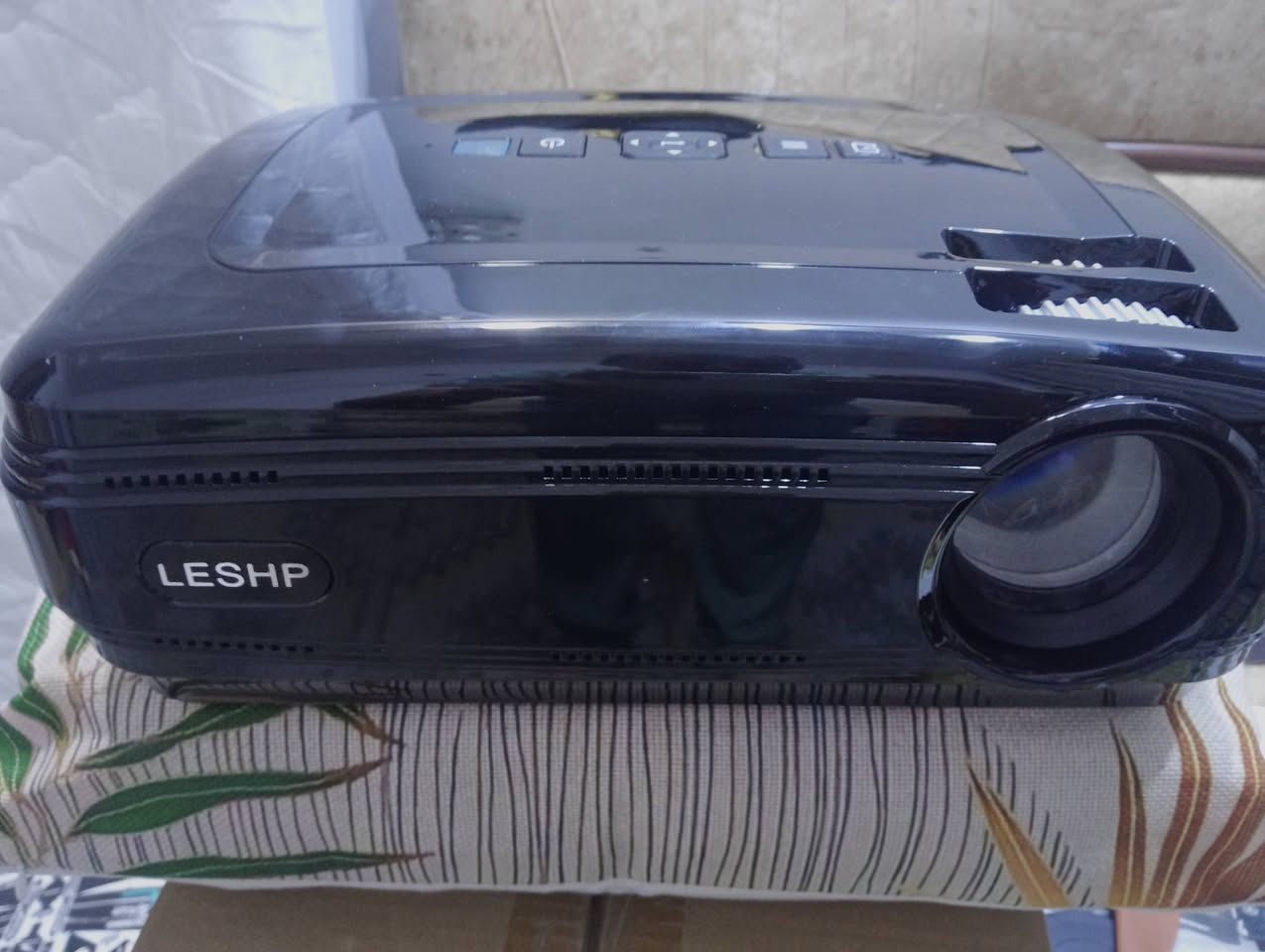 هذا الجهاز هو جهاز عرض ضوئي (Projector) من شركة LESHP، وتحديداً الموديل الشهير BL58 (أو إصدار مقارب له من نفس السلسلة). يُصنف كجهاز بروجكتر منزلي اقتصادي يعمل بتقنية LED.
إليك التفاصيل الكاملة بناءً على مواصفاته التقنية:
​1. التفاصيل والمواصفات التقنية
​الدقة (Resolution): يدعم دقة عرض تصل إلى Full HD 1080p، بينما الدقة الأصلية (Native) هي غالباً 1280x768 بكسل.
​السطوع (Brightness): يصل إلى 3200 لومن (Lumens)، مما يجعله جيداً في الغرف المظلمة أو ذات الإضاءة المنخفضة جداً.
​عمر المصباح: يعمل بتقنية LED، ويصل عمر المصباح فيه إلى حوالي 20,000 ساعة (أي يدوم لسنوات طويلة دون الحاجة لتغيير اللمبة).
​حجم الشاشة: يمكنه عرض صورة تتراوح بين 32 بوصة إلى 200 بوصة، حسب المسافة عن الجدار (يفضل وضعه على مسافة 2-3 متر للحصول على أفضل جودة).
​المنافذ (Connectivity): يحتوي على خيارات توصيل متعددة تشمل:
​2 منفذ HDMI (للكومبيوتر، البلايستيشن، أو الرسيفر).
​2 منفذ USB (لتشغيل الأفلام مباشرة من الفلاشة).
​منفذ VGA و AV.


**إذا كنت صاحب هذا الإعلان وتريد حذفه لأي سبب، رجاءا أرسل رسالة إلى الدعم الفني**