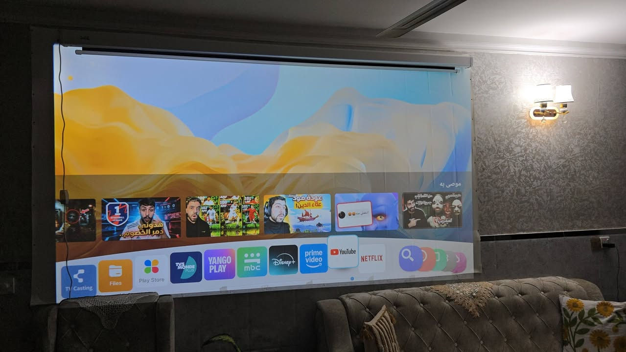 ZOOMCAT C12 – Smart Projector (Whale TV)
وهذه أهم مواصفاته (مجمّعة من بيانات هذا الموديل وما يشابهه):
📺 المواصفات الأساسية
الدقة الأصلية: ‎Full HD 1920×1080 �
نوع العرض: LED  �
العمر الافتراضي للمصباح: حوالي 30,000 ساعة �

التباين: تقريباً ‎20000:1 �

​دعم التطبيقات: الجهاز معتمد من Netflix بشكل مسبق، مما يعني أنه يمكنك تشغيل التطبيق مباشرة من واجهة الجهاز (Smart UI) دون الحاجة لجهاز خارجي في الغالب.
​التركيز التلقائي (Auto Focus): يحتوي على ميزة الضبط التلقائي للعدسة، مما يغنيك عن تدوير العدسة يدوياً للحصول على صورة حادة.
​تصحيح الانحراف التلقائي (Auto Keystone): يقوم الجهاز بتعديل زوايا الصورة تلقائياً لتكون مستقيمة ومربعة حتى لو لم يكن الجهاز موضوعاً في منتصف الشاشة تماماً.
​ملاحظات إضافية من الملصق العلوي:
​يظهر في الملصق الصغير أعلى العلبة كلمة "4K"، وهذا يشير غالباً إلى أن الجهاز يدعم فك تشفير محتوى 4K (أي يمكنه قراءة ملفات 4K وعرضها بدقة 1080p)، وليس أن العدسة تعرض بدقة 4K حقيقية.
​الجهاز مصمم ليكون "Smart Projector" يدعم تطبيقات البث الشهيرة مثل YouTube وNetflix.

للحجز والاستفسار واتس اب

***********
