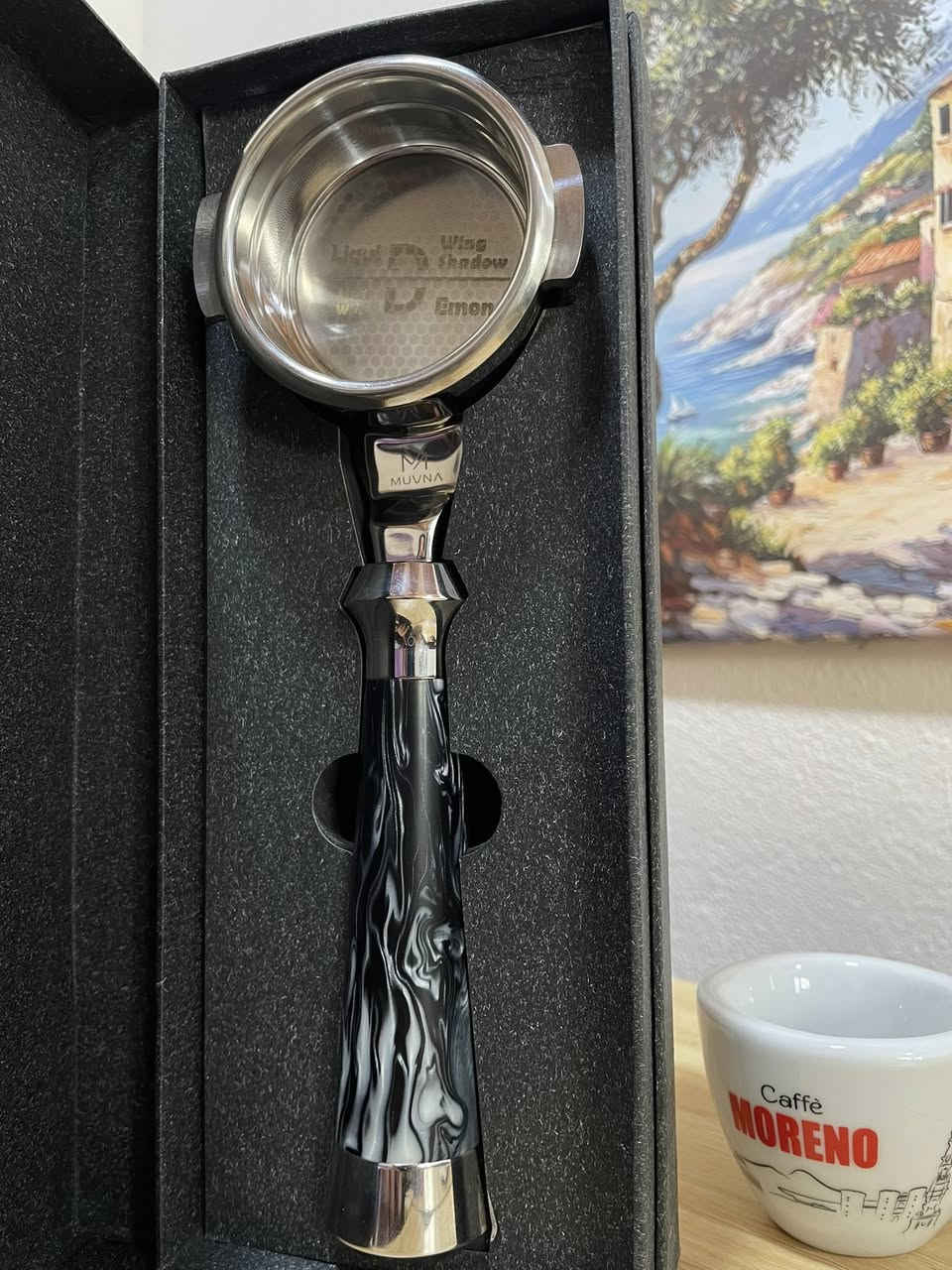 (Bottomless Portafilter) مخصص لآلات الإسبريسو الاحترافية، وهو من إنتاج شركة MUVNA المعروفة في أكسسوارات القهوة المختصة.

إليك تفاصيل ومواصفات هذه القطعة بناءً على الصور:
1. التصميم والمظهر
 المقبض (Handle): يأتي بتصميم مميز جداً بنقشة رخامية متموجة باللونين الأسود والأبيض (Resin/Acrylic swirl)، مع نهايات معدنية مصقولة من الكروم اللامع تعطي ثقلاً وتوازناً أثناء الاستخدام.

 الرأس (Head): مصنوع من المعدن المقاوم للصدأ (Stainless Steel) عالي الجودة والمصقول بعناية.
 العلامة التجارية: شعار MUVNA محفور بوضوح على الجزء المعدني الواصل بين المقبض والرأس.

2. السلة (Basket) المرفقة
 البورتافلتر يأتي ومعه سلة ترشيح احترافية مدمجة.
 تسمى هذه السلة في هذا الإصدار بـ "Liquid Demon" أو "Wing Shadow" كما هو محفور في قاع السلة داخلياً.
 تتميز السلة بنمط ثقوب دقيق جداً (توزيع متناسق يشبه خلايا النحل في الأطراف)، وهو تصميم مخصص لتحسين التدفق (High-flow) لضمان استخلاص متساوٍ لكامل كعكة القهوة (Puck) واستخراج نكهات أكثر وضوحاً وقوام غني.


**إذا كنت صاحب هذا الإعلان وتريد حذفه لأي سبب، رجاءا أرسل رسالة إلى الدعم الفني**