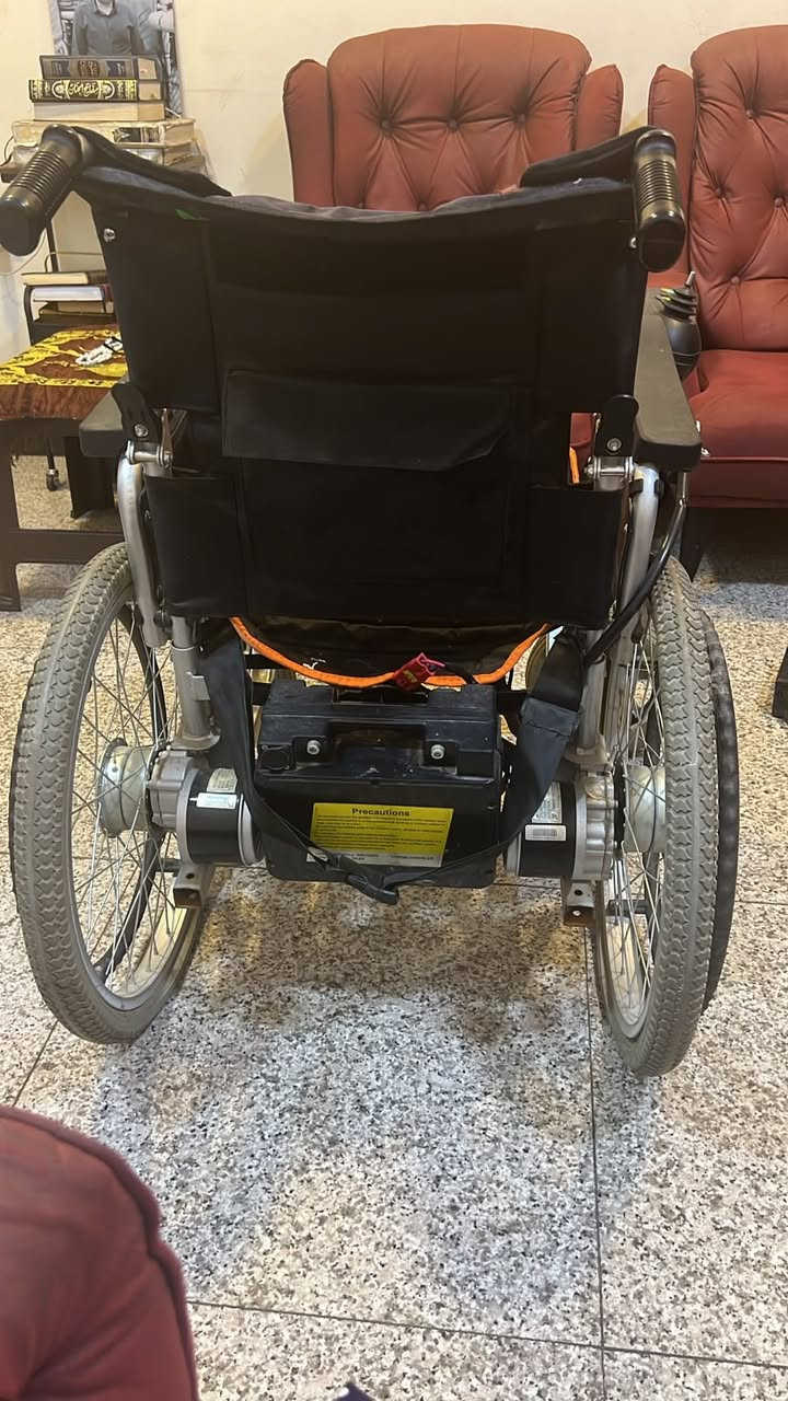السلام عليكم 

كرسي متحرك كهربائي قياسي قابل للطي بحالة جيدة (Standard Folding Electric Wheelchair)، وهو من الموديلات العملية والشائعة جداً.

* الهيكل (Frame): مصنوع من الألمنيوم أو الفولاذ الخفيف المقاوم للصدأ، ويتميز بوجود مقصّات متقاطعة (X-brace) أسفل المقعد تتيح إمكانية طي الكرسي بسهولة ليدخل في صندوق السيارة.

* نظام الدفع والمحركات: يعتمد على محركين كهربائيين منفصل لتوفير قوة دفع مستقلة وعزم دوران جيد.
* البطارية: يحتوي على حقيبة بطارية مربعة سوداء كبيرة (غالباً بطارية أسيد/جل بجهد 24V وسعة تتراوح بين 12Ah إلى 20Ah) مثبتة في الخلف وقابلة للإزالة للشحن.

* الإطارات:
    * الخلفية: إطارات كبيرة ممتصة للصدمات مع درجات (Treads) تعطي ثباتاً أفضل على الطرق غير المستوية.
    * الأمامية: عجلات صلبة صغيرة (عجلات توجيه) مدعومة بمحاور قوية.

* نظام التحكم (Joystick): يظهر مقبض التحكم (العصا الذكية) على مسند اليد الأيمن لتوجيه الحركة 360 درجة والتحكم بالسرعة.

* الملحقات الظاهرة 
* مساند الأرجل (Footrests) قابلة للتفكيك والازالة 
    * وسادة مقعد إضافية سوداء بحواف برتقالية لتوفير راحة أكبر أثناء الجلوس الطويل.

السعر 450 الف وبيه مجال بسيط 

مكاني بغداد 

للتواصل  ***********

