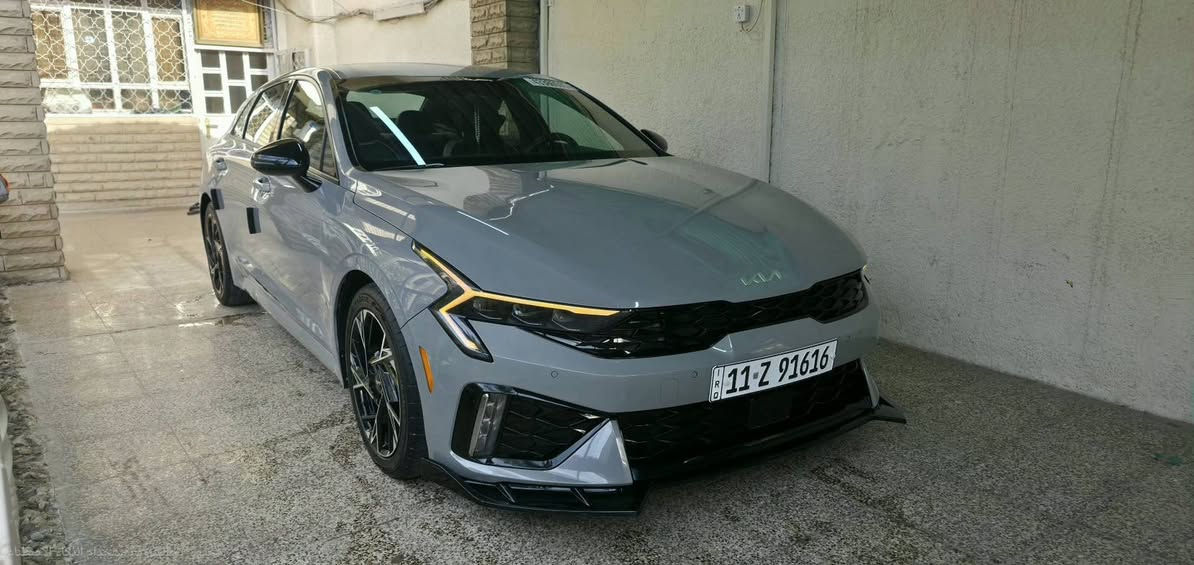 🚗 للبيع: كيا K5 موديل 2025 (GT-Line) - بحالة الوكالة
للراغبين بالتميز والنظافة.. سيارة ملكية ومواصفات تخبل
✅ المواصفات والحالة العامة:
 * الموديل: 2025 (K5).
 * المحرك: 2500 تنفس طبيعي (أقوى وأحمل محرك مرغوب بالعراق).
 * الفئة: GT-Line (فول مواصفات عدا البانوراما) - شكل رياضي وهيبة بالشارع.
ماشيه 25800الف km قابل للزياده
 * الرقم: بغداد مميز (91616)بإسمي والتحويل مباشر ثاني يوم).
✨ نظافة البودي (الكفالة):
 * السيارة "كلين" وكفالة عامة من الحادث والصبغ. عدا الدعاميه راجعه نفسها وطعجه بالجاملغ راجع بارد وكلشي موجود بالصور
 * كل الليبلات أصلية (بدون فتح برغي واحد).
 * تعديل "بارد" احترافي جداً  
 * السيارة طلع  بيها طبقة كلير (جلاتين)  بالجاملغات والبنيد حماية للبچم بالكامل (يعني لا شخوط ولا نقرات حصى). كلير يعني لا صبغ ولا معجون.
🛠 الإضافات المميزة (صارف عليها بيدي):
 * إضافات خارجية مميزة (لحية أمامية + سبايدر خلفي) بقيمة 300$.
 * إنارة داخلية (Ambient Light) 65 لون تتحكم بيها براحتك.
 * تفعيل نظام اليوتيوب على شاشة السيارة الأصلية.
🛡 شرط الفحص:
السيارة جديدة بمعنى الكلمة، وشرط السونار وين ما يعجبك وبأي مركز فحص بالعراق. إذا طلع برغي مصلح أو قطعة مصبوغة، فحصك عليه!
> ملاحظة للمشتري: السيارة متعوب عليها وجاهزة من كلشي، شغل واطلع.
للتواصل ***********
