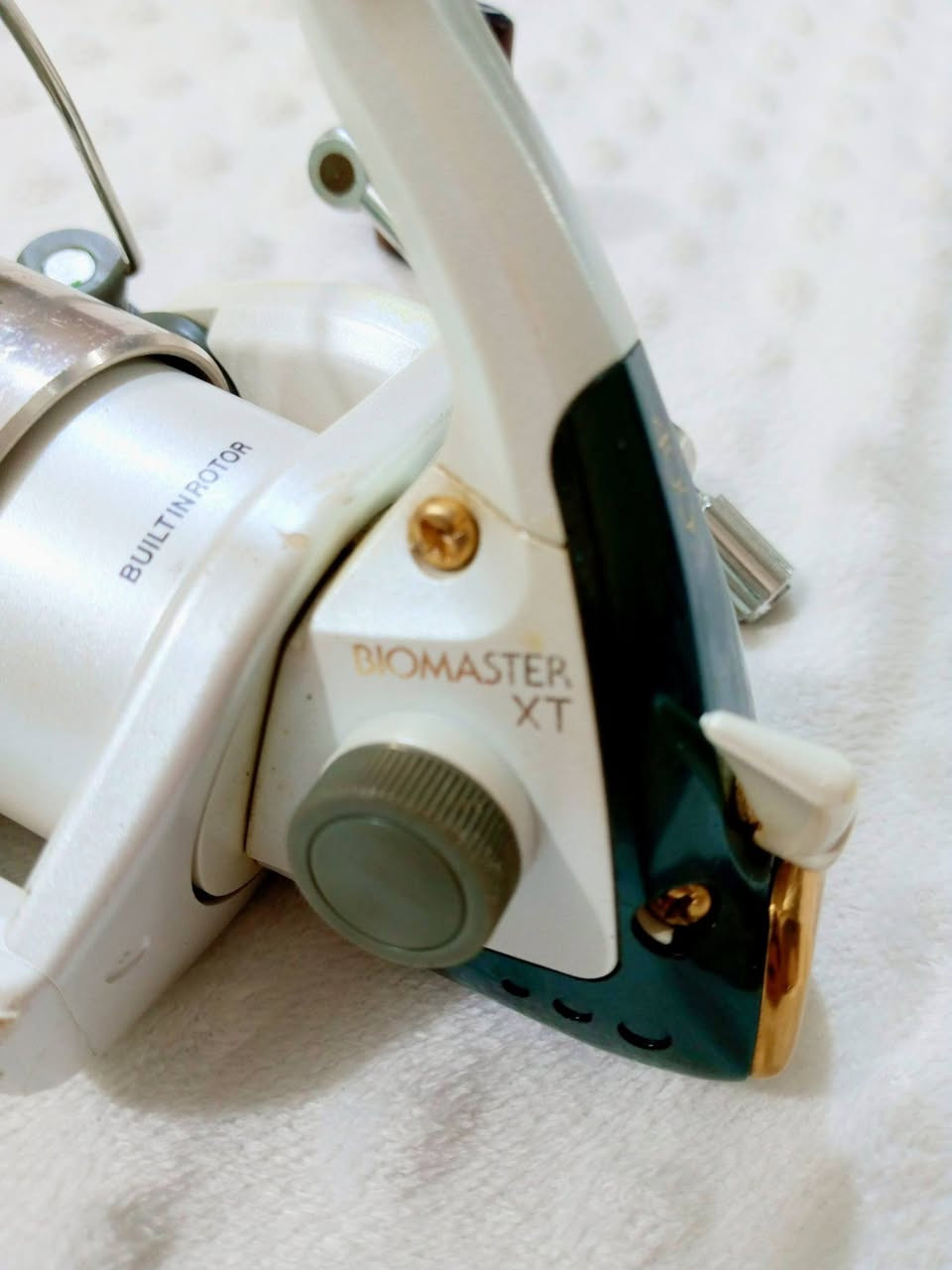 ✓✓✓ااسعر خاص 
رقم الواتساب ‏‪***********‬‏
​الاسم : شي مانو بايو ماستر (Shimano Biomaster XT 4000).
​بلد الصنع: ياباني أصلي (Made in Japan) كما هو محفور على جسم الماكينة.
​الحجم: 4000.
​سعة الخيط (الرواند):
​خيط نمرة 3 يشيل 200 متر.

​خيط نمرة 4 يشيل 150 متر.

​خيط نمرة 5 يشيل 110 متر
 الماكينة (Shimano Biomaster XT 4000) تعتبر من "الأنتيكات" اليابانية الراقية اللي لها ثقلها ومكانتها عند الصيادين القدامى. إليك المواصفات الميكانيكية والفنية الكاملة لها:

⚙️ المواصفات الميكانيكية والجسد

مادة الصنع: جسم الماكينة (Body) مصنوع من المعدن بالكامل ليعطيها متانة عالية وتحمل صدمات، أما بكرة الخيط (Spool) فهي مصنوعة من الألمنيوم/الغرافيت المطلي مع حافة ذهبية ناعمة لتقليل الاحتكاك مع الخيط أثناء الرمي.

الذراع (Handle): ذراع متين من المعدن وقابل للطي (Folding Handle) بزر جانبي لتسهيل الخزن، مع مقبض خشبي كلاسيكي مريح جداً أثناء التدوير.

الدوران والتروس: تحتوي على منظومة تروس يابانية داخلية مصنوعة من النحاس والألمنيوم الصلب، مما يمنحها سلاسة فائقة وقوة سحب (Drag Power) ممتازة للأسماك الكبيرة.
