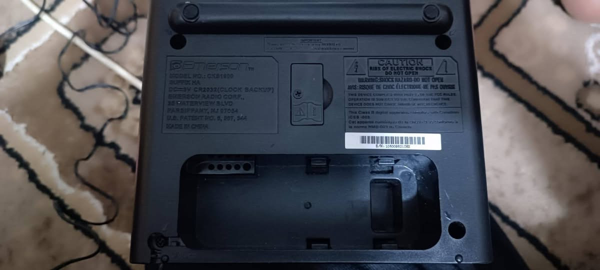 يظهر في الصورة راديو ساعة منبه مزدوج من نوع Emerson SmartSet. يتميز هذا الجهاز بنظام ضبط الوقت التلقائي الحاصل على براءة اختراع، حيث يقوم تلقائياً بضبط السنة والشهر والتاريخ والوقت الصحيح بمجرد توصيله بالكهرباء.
المواصفات والمميزات الرئيسية:

الشاشة: شاشة LED رقمية مقاس 0.9 بوصة باللون الأخضر الجيد (Jade Green)، وهي سهلة القراءة وتتضمن خاصية التحكم في السطوع (Dimmer) لتكون مريحة للعين في الظلام.

الراديو: راديو AM/FM بضبط رقمي، يتيح لك الاستيقاظ على محطتك المفضلة أو على صوت المنبه التقليدي (Buzzer).

المنبه المزدوج: يمكن برمجة المنبه ليعمل في أيام الأسبوع فقط، أو في عطلات نهاية الأسبوع، أو طوال أيام الأسبوع السبعة.

وظائف إضافية: يتضمن الجهاز وظيفة الغفوة (Snooze)، ومؤقت للنوم (Sleep Timer) يتيح لك النوم على صوت الموسيقى.

العرض الإضافي: يمكن للساعة عرض الشهر والتاريخ بلمسة زر واحدة.


**إذا كنت صاحب هذا الإعلان وتريد حذفه لأي سبب، رجاءا أرسل رسالة إلى الدعم الفني**