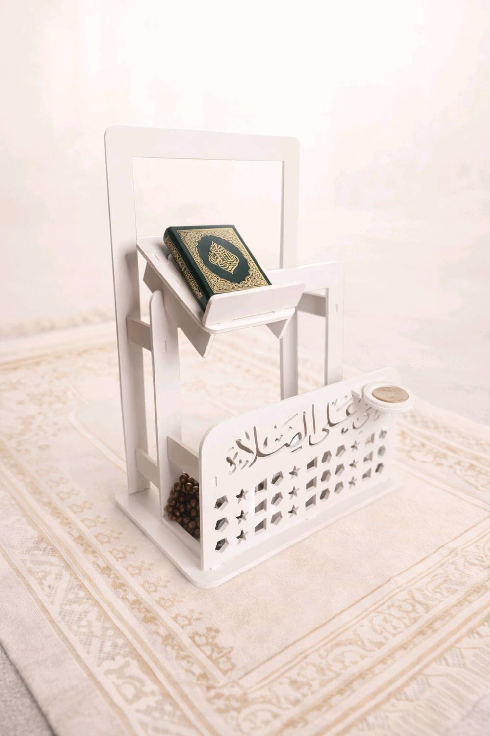 ستاند قرآن وصلاة متعدد الاستخدام مع حامل مصحف وحامل سجادة – تصميم مزخرف

• منظم عملي وأنيق للقرآن الكريم ومستلزمات الصلاة بتصميم مزخرف يناسب المنزل أو المصلى.

• حامل علوي مائل لوضع المصحف أو الكتاب بثبات أثناء القراءة.

• إطار خلفي لتعليق سجادة الصلاة بشكل مرتب.

• واجهة أمامية مزخرفة بعبارة «حي على الصلاة» ونقوش هندسية مفرغة.

• حامل دائري جانبي مخصص لوضع تربة الصلاة.

• تصميم قائم على قاعدة ثابتة مع هيكل متكامل بلون أبيض.

•الابعاد: 70*47*29 سم

• النوع: ستاند قرآن وصلاة قائم
• الزخرفة الأمامية: عبارة «حي على الصلاة» مع نقوش مفرغة
• يحتوي على: حامل مصحف مائل + علاقة سجادة + حامل دائري جانبي