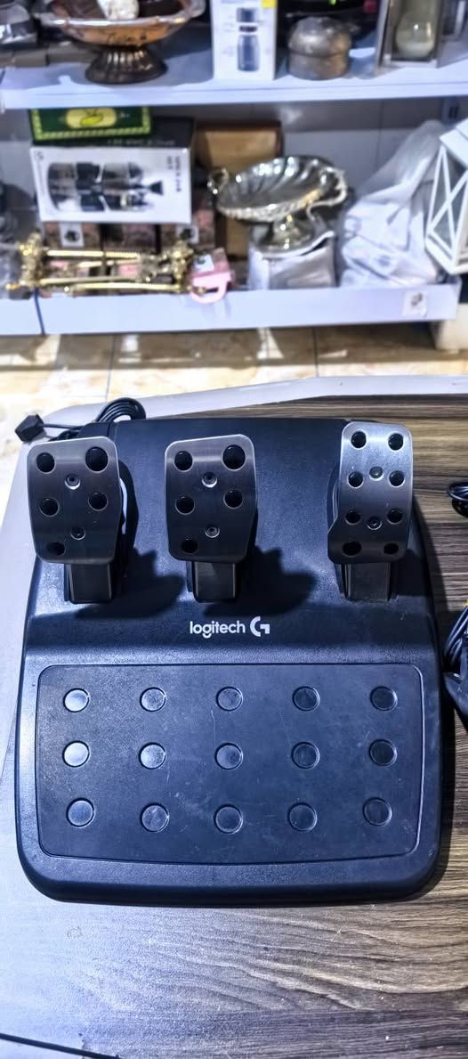 عجلة القيادة الاحترافية Logitech G923 Trueforce، وهي المخصصة لأجهزة PlayStation (PS4 / PS5) والكمبيوتر (PC) (ويتضح ذلك من تصميم الأزرار التي تحمل شعارات أسهم التوجيه وزر الـ PlayStation في الأسفل).إليك أبرز مواصفات ومميزات هذا الدركسون:⚙️ المواصفات والميزات الأساسيةتقنية TRUEFORCE: جيل جديد من نظام الاستجابة للاهتزاز (Force Feedback) يتزامن مباشرة مع فيزياء الألعاب ليعطيك شعوراً حقيقياً بالطريق، والمنعطفات، وهدير المحرك.درجة الدوران: يلتف حتى 900 درجة (لفتين ونصف) مثل سيارات السباق الحقيقية تماماً.التصميم والمواد: عجلة مكسوة بالجلد الطبيعي المخيط يدوياً، مع مبدلات سرعة (Shift Paddles) ومحور مركزي مصنوع من الألمنيوم المتين.مؤشر RPM: إضاءة LED مدمجة أعلى المقود تبين لك عدد دورات المحرك لتحديد الوقت المثالي لتبديل السرعات.محدد اختيار بـ 24 نقطة: قرص دوار مدمج يتيح لك تعديل قوة الفرامل، العزم، والاستقرار مباشرة أثناء القيادة.


**إذا كنت صاحب هذا الإعلان وتريد حذفه لأي سبب، رجاءا أرسل رسالة إلى الدعم الفني**