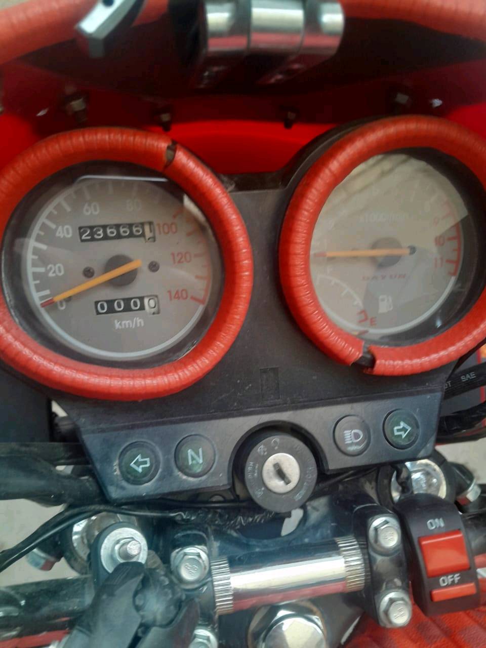 درّاجة نارية نوع دايون مع غطاء برتقالي خاص للتنجيد لمحافظة على المقاعد. بحالة ممتازة، مثالية للتنقل داخل المدينة والرحلات اليومية. العداد يظهر 23666 كيلومتر. متوفرة في بغداد وجاهزة للاستخدام المباشر.